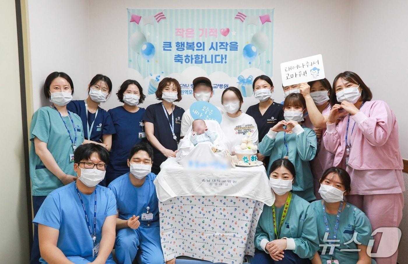 본문 이미지 - 충남대학교병원 신생아중환자실에서 무사히 치료받고 퇴원한 이른둥이 환아와 가족들이 의료진과 기념사진을 촬영하고 있다.(충남대병원 제공) /뉴스1