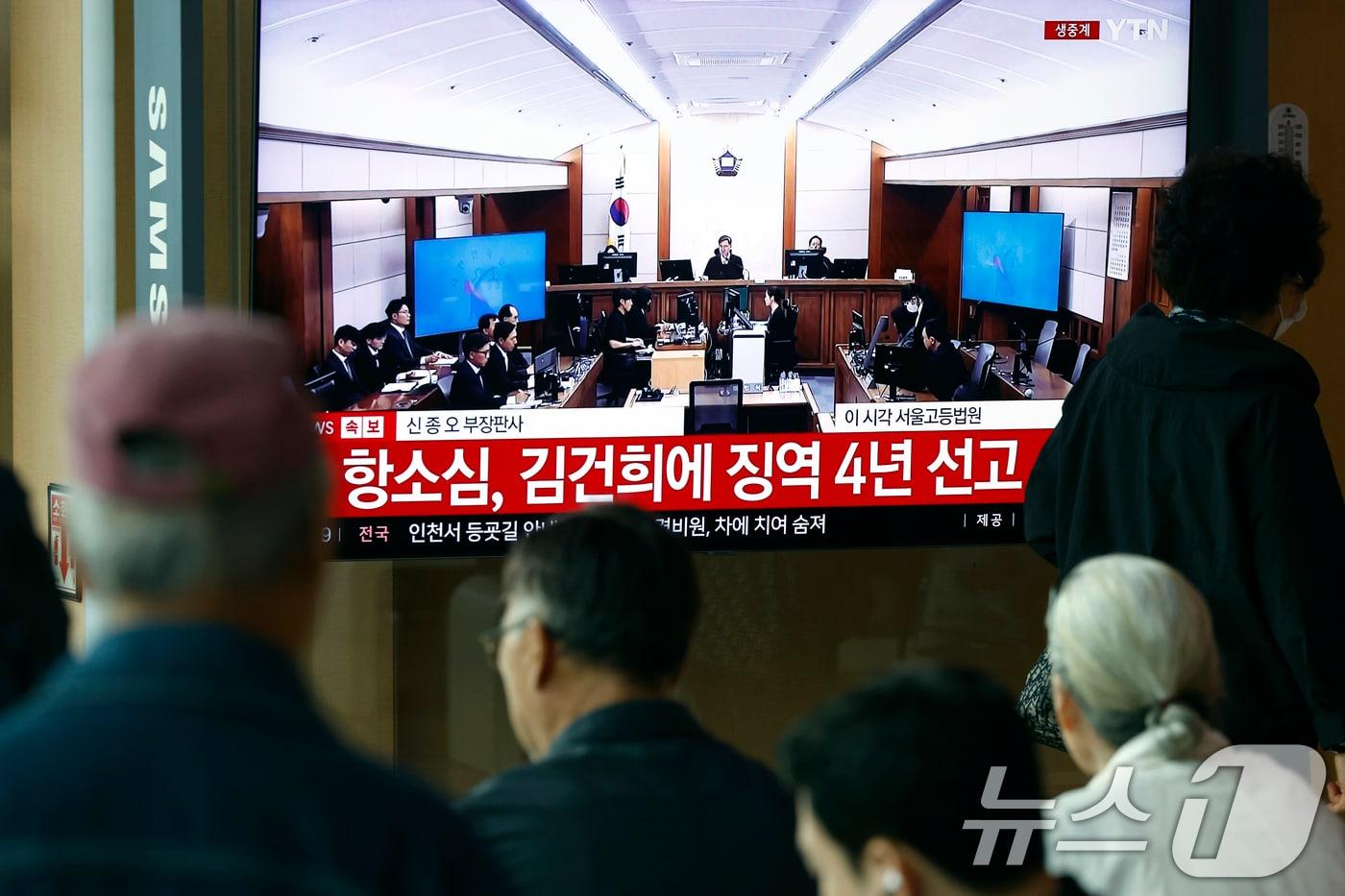 본문 이미지 - 28일 오후 서울시 용산구 한강대로 서울역 대합실에서 시민들이 자본시장과 금융투자업에 관한 법률 위반, 정치자금법 위반, 특정범죄 가중처벌 등에 관한 법률 위반(알선수재) 혐의를 받는 김건희 여사의 항소심 선고공판 생중계를 지켜보고 있다. 김 여사는 징역4년을 선고 받았다. 2026.4.28 ⓒ 뉴스1 박정호 기자