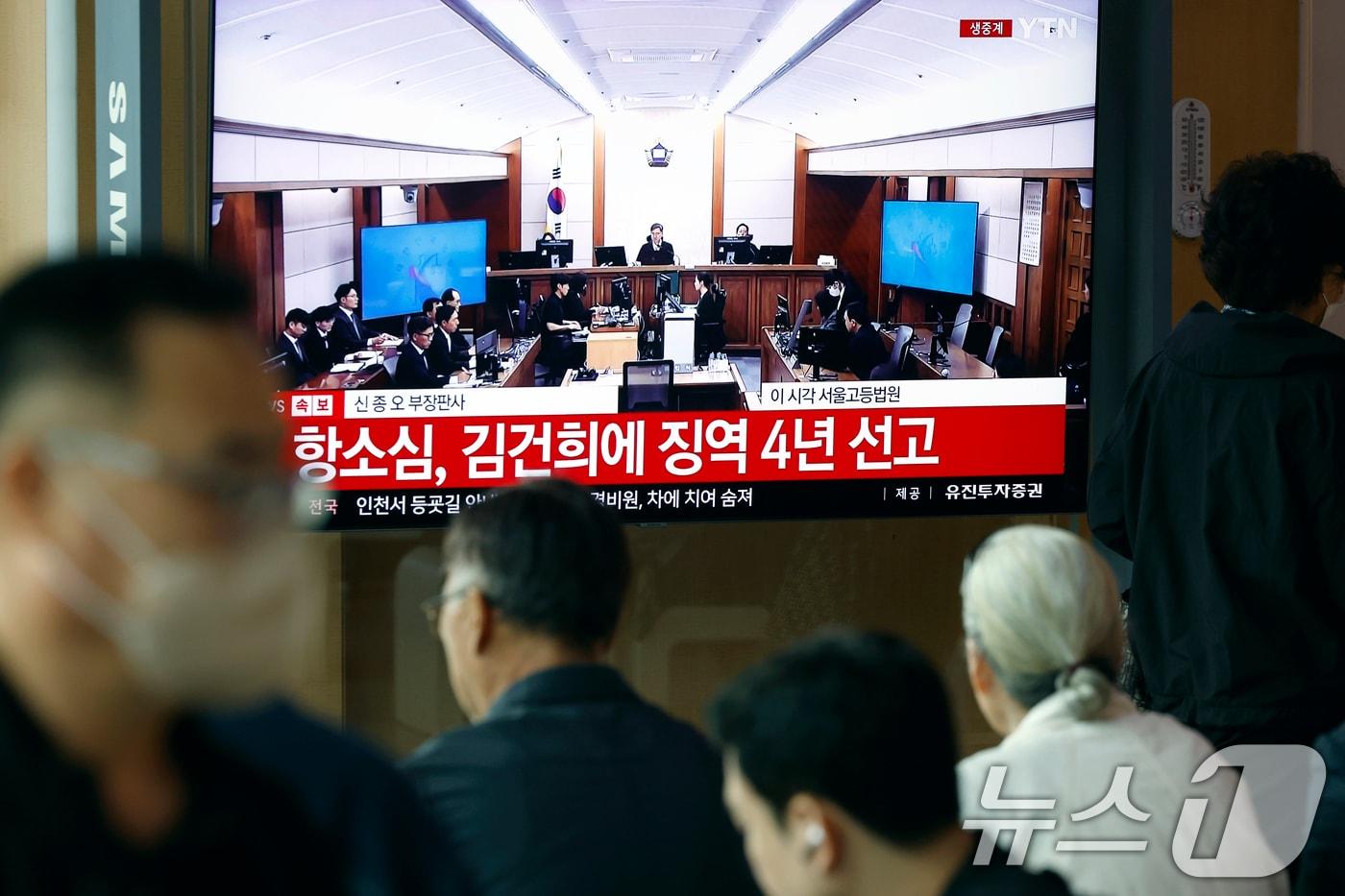 본문 이미지 - 28일 오후 서울시 용산구 한강대로 서울역 대합실에서 시민들이 자본시장과 금융투자업에 관한 법률 위반, 정치자금법 위반, 특정범죄 가중처벌 등에 관한 법률 위반(알선수재) 혐의를 받는 김건희 여사의 항소심 선고공판 생중계를 지켜보고 있다. 김 여사는 징역4년을 선고 받았다. 2026.4.28 ⓒ 뉴스1 박정호 기자