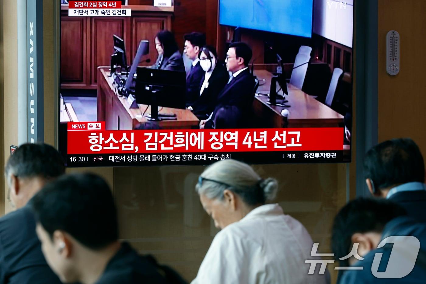 본문 이미지 - 28일 오후 서울시 용산구 한강대로 서울역 대합실에서 시민들이 자본시장과 금융투자업에 관한 법률 위반, 정치자금법 위반, 특정범죄 가중처벌 등에 관한 법률 위반(알선수재) 혐의를 받는 김건희 여사의 항소심 선고공판 생중계를 지켜보고 있다. 김 여사는 징역4년을 선고 받았다. 2026.4.28 ⓒ 뉴스1 박정호 기자