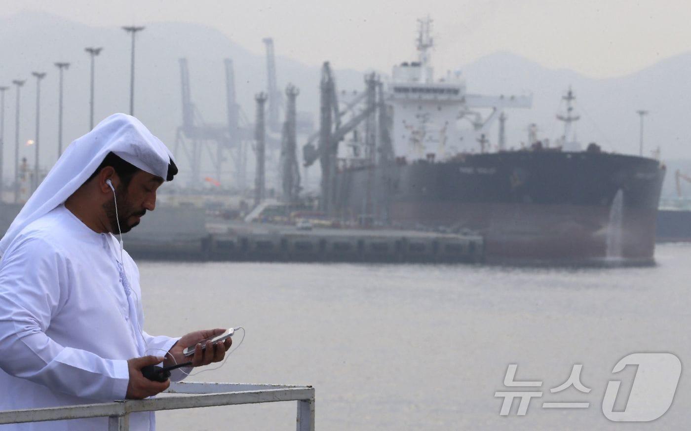 본문 이미지 - 2016년 9월 21일, 초대형 유조선을 위한 도크 개장식이 열린 푸자이라의 석유 터미널에서 한 아랍에미리트(UAE) 남성이 서 있다. ⓒ AFP=뉴스1