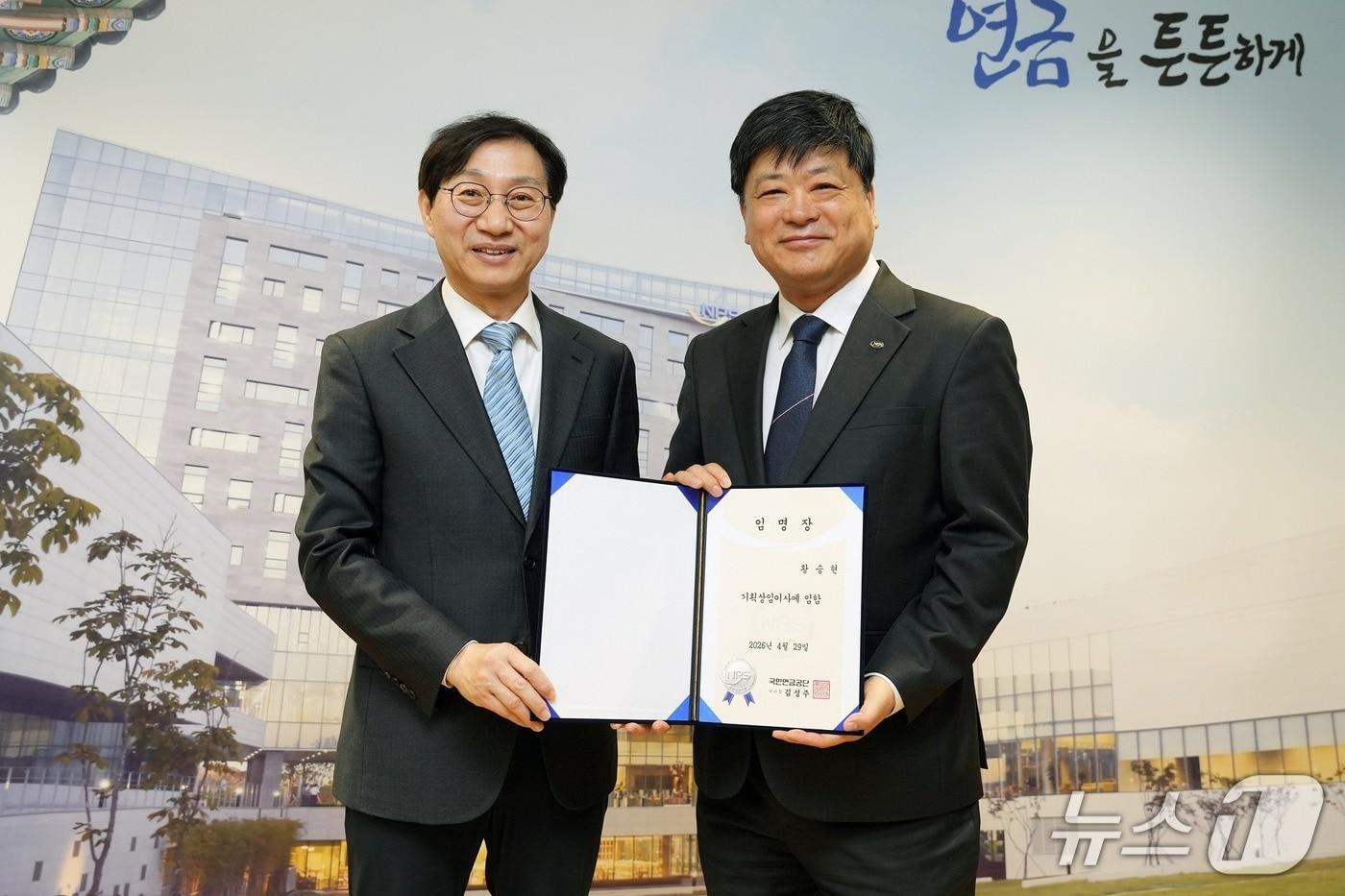 본문 이미지 - 김성주 국민연금공단 이사장(왼쪽)이 29일 황승현 국민연금공단 신임 기획이사에게 임명장을 전달하고 기념촬영을 하고 있다.(국민연금공단 제공)