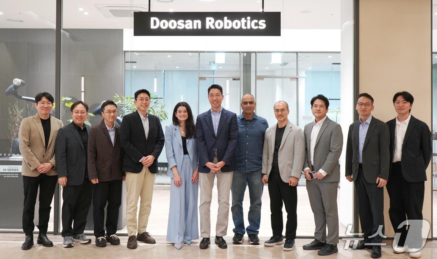 본문 이미지 -  김민표(왼쪽 여섯째) 두산로보틱스 대표와 매디슨 황(왼쪽 다섯째) 엔비디아 수석 이사가 관계자들과 기념사진을 촬영하고 있다. (사진제공 = 두산로보틱스)