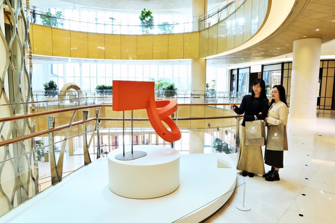 본문 이미지 - 서울 송파구에 위치한 국내 최대 명품관 에비뉴엘 잠실점의 각층에 연출한 '아트 VM' 작품을 바라보는 고객들의 모습(롯데백화점 제공)