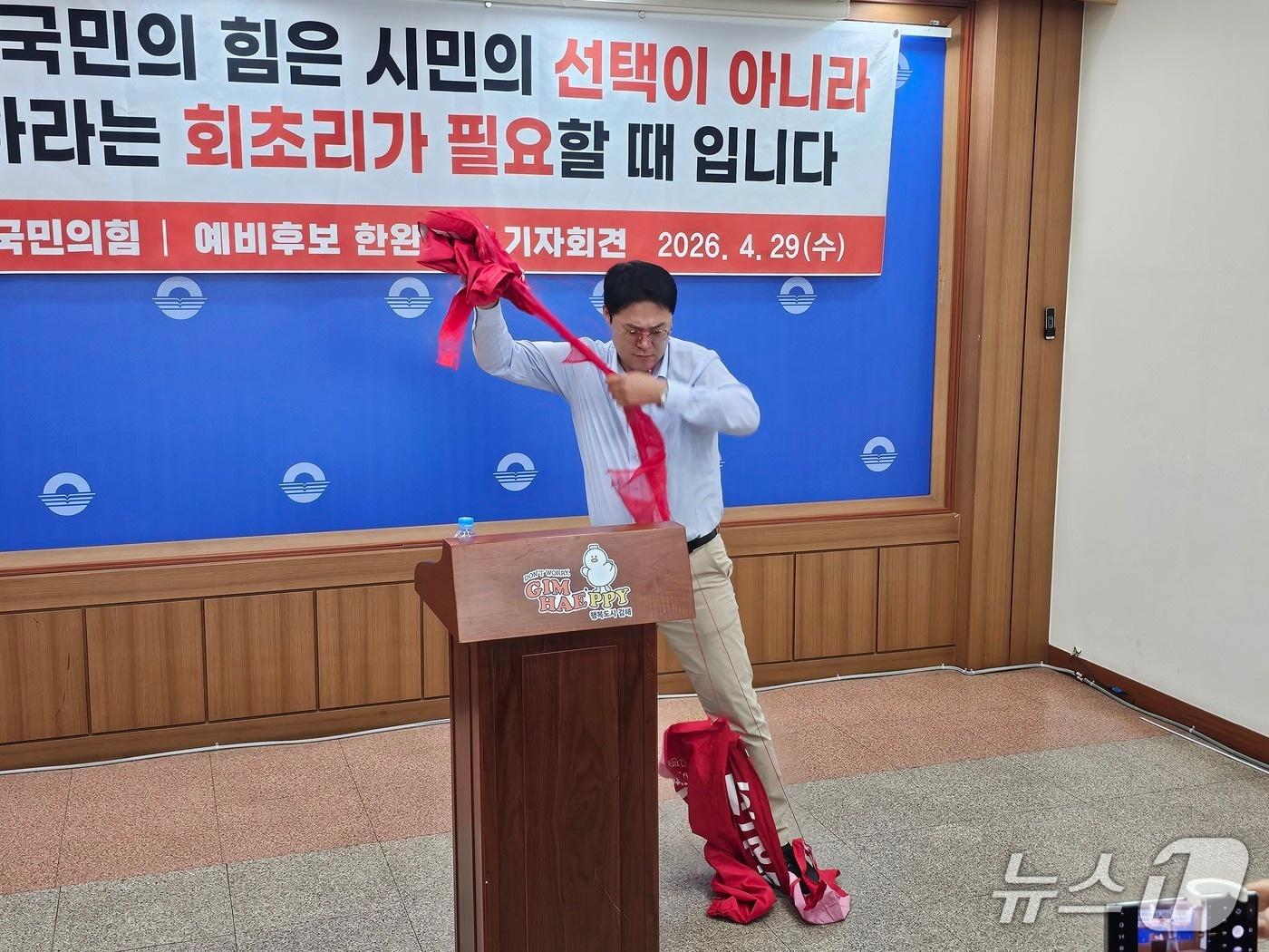 본문 이미지 - 김해시의원 라 선거구에 국민의힘 공천을 신청했다가 사퇴한 한완희 김해시 주민 참여예산위원이 29일 김해시청 프레스센터에서 기자회견을 열고 당 공천 과정을 비판하면서 예비후보 선거운동복을 찢고 있다. 2026.4.29 ⓒ 뉴스1 박민석 기자