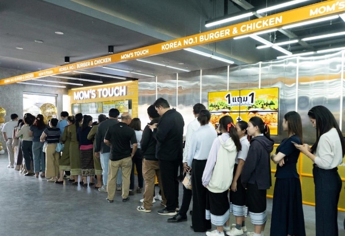 본문 이미지 - 라오스 수도 비엔티안 방사이 지역에 위치한 맘스터치 현지 MF 1호점 오픈 당일 라오스 현지 소비자들이 입장하기 위해 줄을 서 있다.(맘스터치 제공)