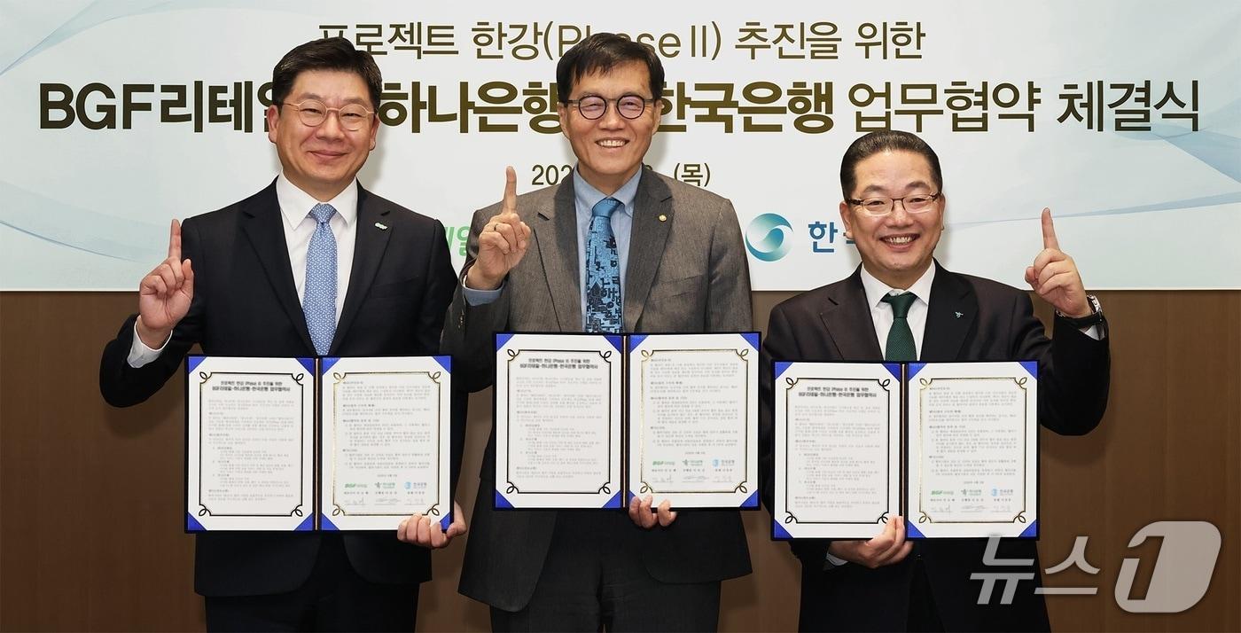 본문 이미지 - 하나은행은 지난 2일 오후 한국은행 본관에서 한국은행·BGF리테일과 함께 예금 토큰 실증 사업인 ‘프로젝트 한강 2단계 사업’의 성공적인 추진과 디지털 금융 혁신을 위한 3자 업무협약을 체결했다. 이날 협약식에 참석한 이호성 하나은행장(사진 오른쪽)이 이창용 한국은행 총재(사진 가운데), 민승배 BGF리테일 대표이사(사진 왼쪽)와 함께 협약서를 들고 기념촬영을 하고 있다. 2026.04.02 / 사진제공=하나은행