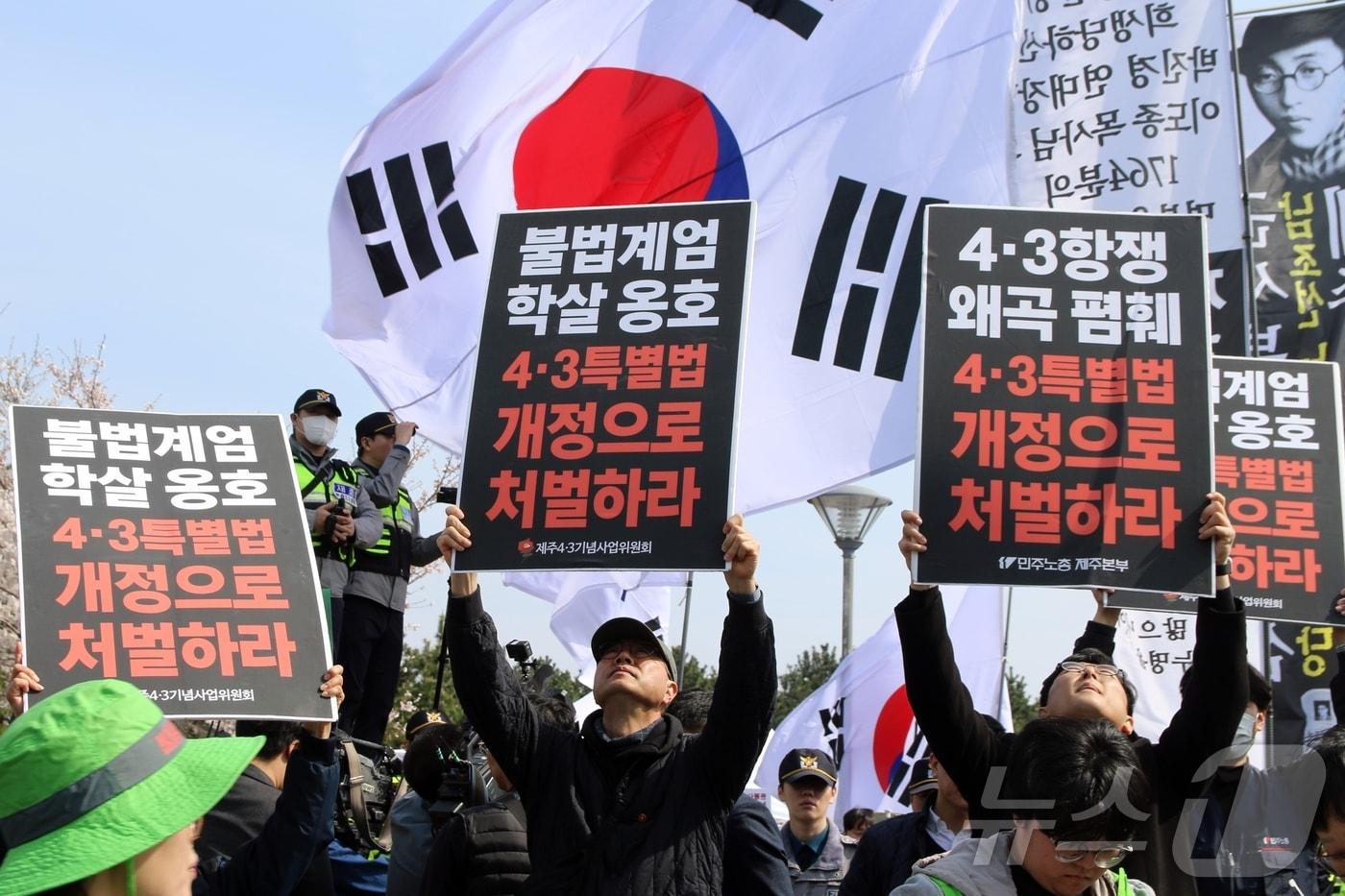 본문 이미지 - 78주년 제주4·3희생자 추념식이 열리고 있는 3일 오전 제주시 봉개동 제주4·3평화공원 인근에서 민주노총 관계자들이 '불법 계엄 학살 옹호 4·3특별법 개정으로 처벌하라'는 팻말을 들고 있다. 이날 이곳에서는 추념식과 동시에 일부 극우단체 50여 명이 집회 신고를 했다.2026.4.3 ⓒ 뉴스1 홍수영 기자