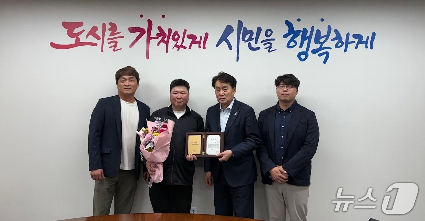 본문 이미지 - 경기 군포시 환경미화원 배영제 씨(왼쪽 두 번째)가 하은호 시장(오른쪽 두 번째)으로부터 '청소분야 지역사회 청렴실천 유공' 표창을 받고 기념촬영을 하고 있다. (군포시 제공. 재판매 및 DB 금지) 2026.4.3/뉴스1