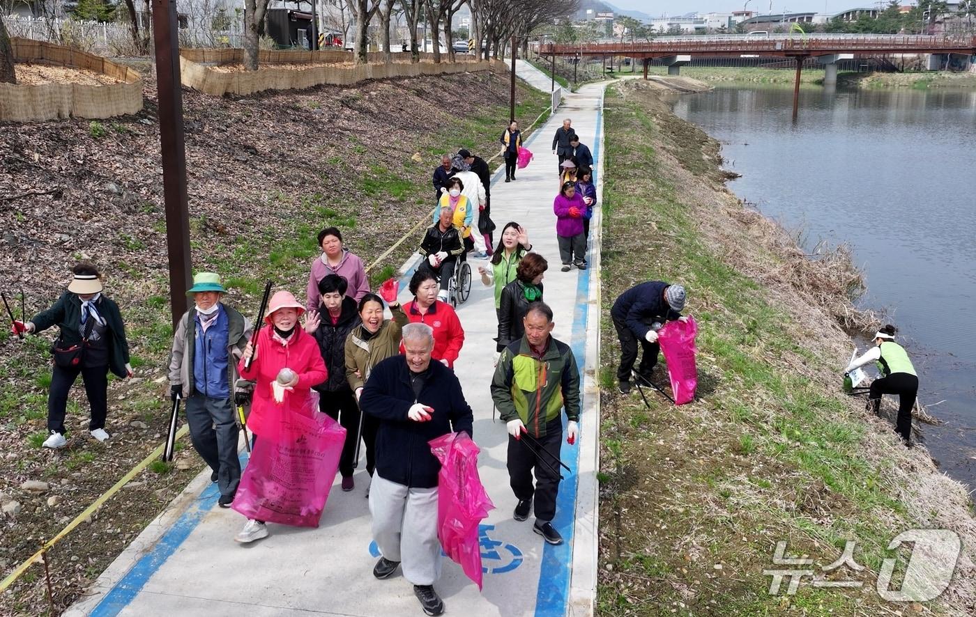 본문 이미지 - 괴산군장애인복지관이 3일 개최한 '청정괴산 자연울림' 친환경 플로깅 걷기대회 참석자들이 동진천변에서 쓰레기를 주우며 걷고 있다.(괴산군 제공. 재판매 및 DB금지)