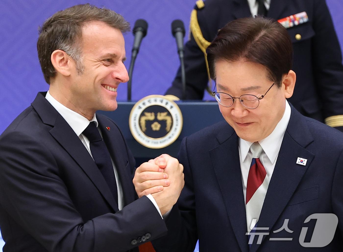 본문 이미지 - 이재명 대통령과 에마뉘엘 마크롱 프랑스 대통령이 3일 청와대 영빈관에서 열린 국빈 방한 환영 오찬에서 손을 맞잡고 있다. 2026.4.3 ⓒ 뉴스1 허경 기자