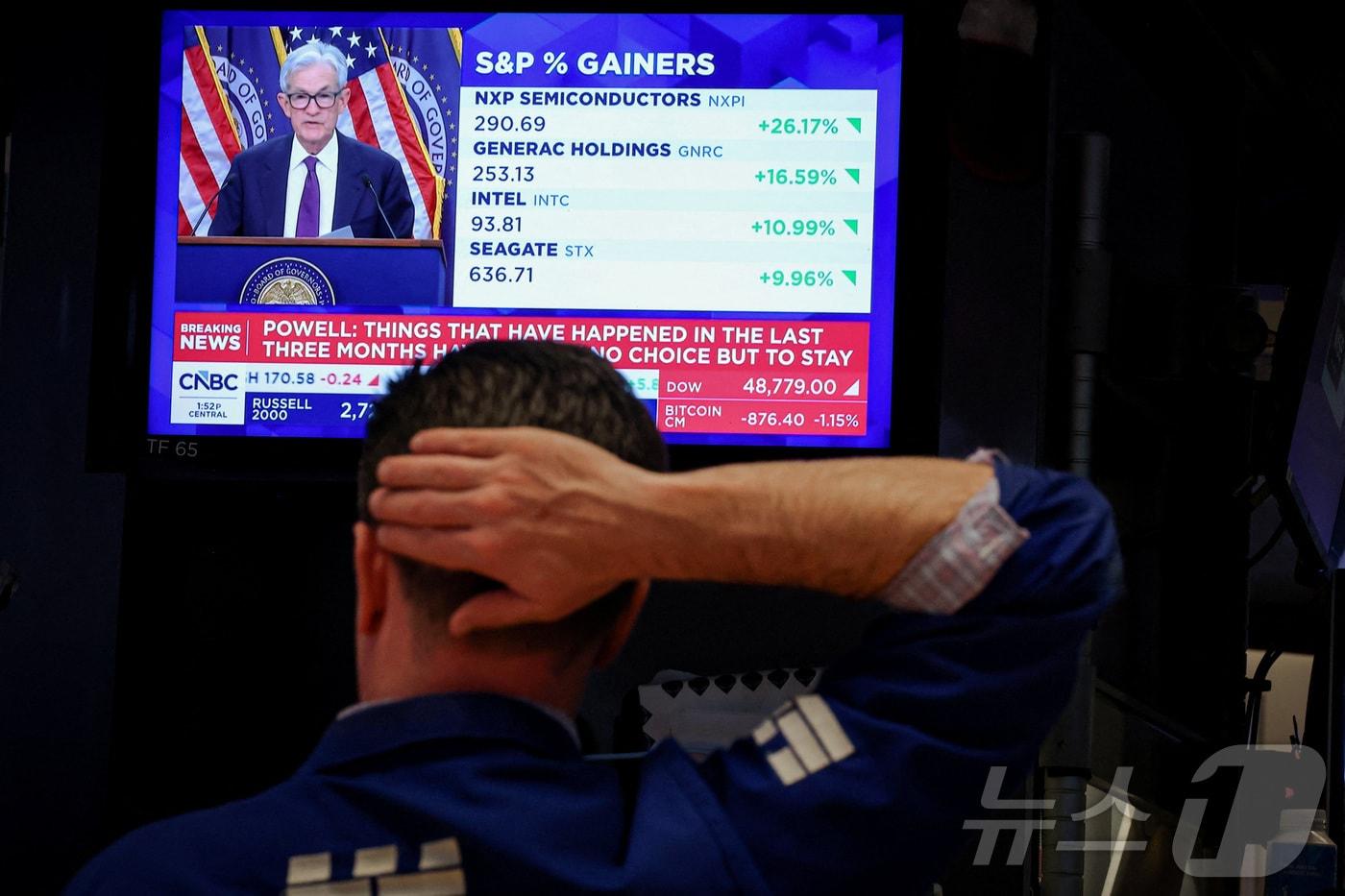 본문 이미지 - 뉴욕증권거래소(NYSE)에서 트레이더가 업무를 보는 가운데 29일(현지시간) 전광판에는 제롬 파월 미국 연방준비제도(Fed) 의장의 금리 결정 이후 기자회견 장면이 중계되고 있다. 2026. 4.29 ⓒ 로이터=뉴스1