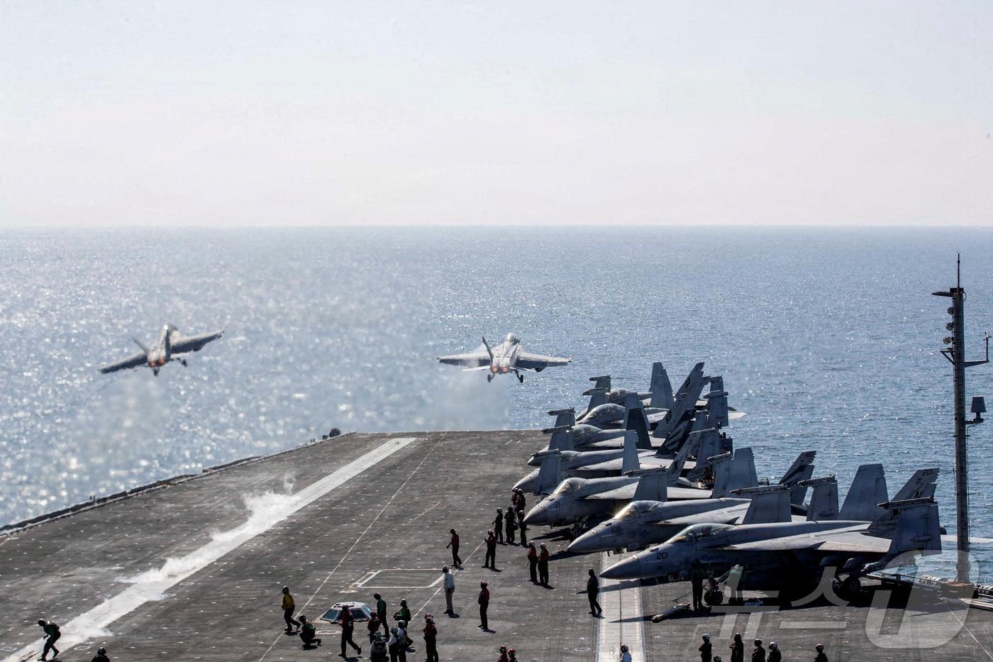 본문 이미지 - 2026년 3월 3일, 작전 중인 미국 해군의 니미츠급 항공모함 에이브러햄 링컨(CVN-72)함의 비행갑판에서 F/A-18 슈퍼 호넷 전투기 두 대가 이란을 겨냥한 '에픽 퓨리' 작전 지원을 위해 출격하고 있다. ⓒ 로이터=뉴스1