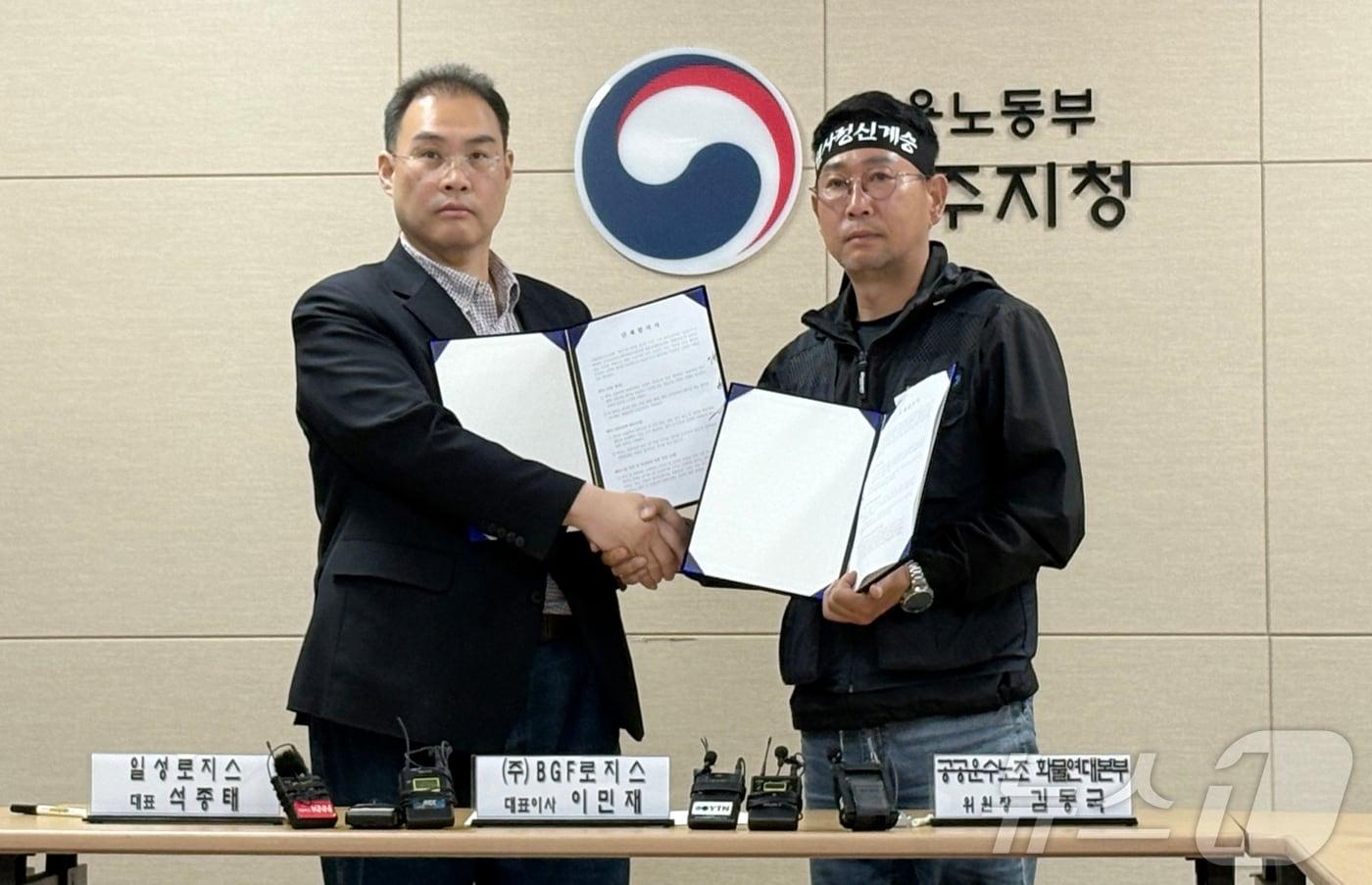 본문 이미지 - 이민재 BGF 로지스 대표(왼쪽)와 민주노총 화물연대 김동국 위원장이 30일 경남 진주시 고용노동부 진주지청에서 열린 단체합의서 조인식에서 악수하고 있다. 2026.4.30 ⓒ 뉴스1 강미영 기자