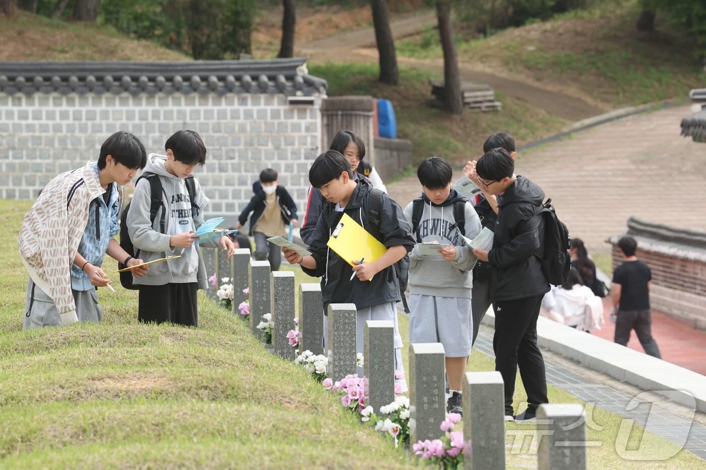본문 이미지 - 30일 오전 광주 북구 운정동 국립5·18민주묘역에서 학생들이 체험학습 활동지를 작성하고 있다. 2026.4.30 ⓒ 뉴스1 조수민 수습기자