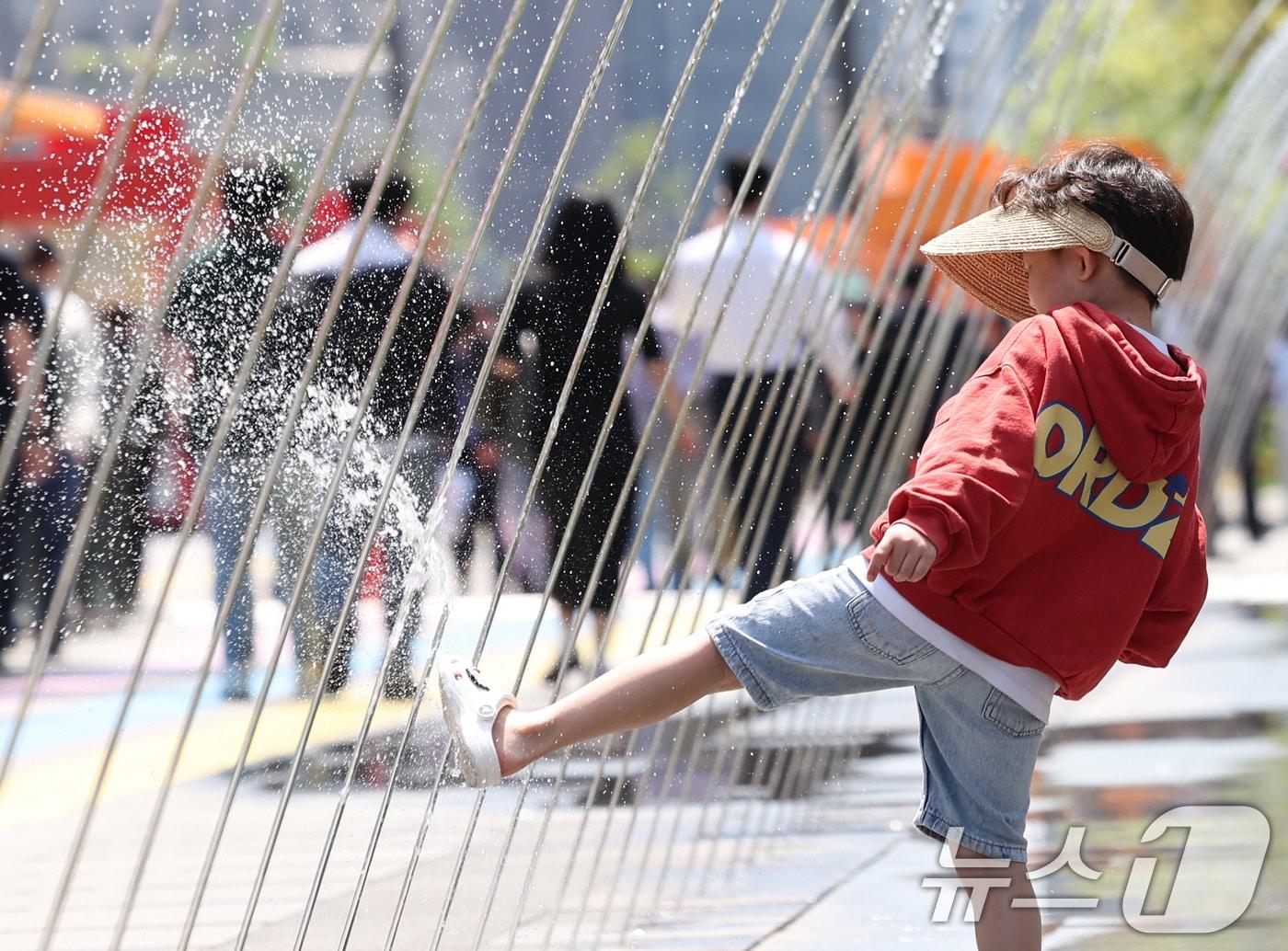 본문 이미지 - 서울 낮 최고 기온이 22도까지 오르는 등 초여름 날씨를 보인 30일 서울 종로구 광화문광장 분수 터널을 찾은 한 아이가 물놀이를 하며 더위를 식히고 있다. 2026.4.30 ⓒ 뉴스1 임지훈 인턴기자