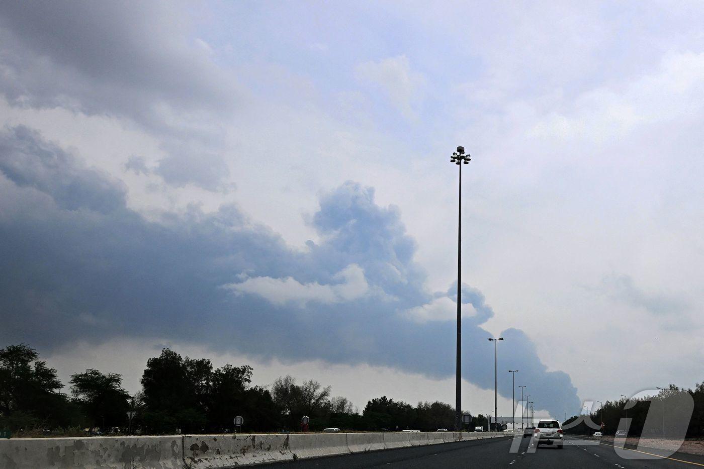 본문 이미지 - 25일(현지시간) 이란이 드론 공격으로 연료 저장 시설을 타격한 것으로 알려진 후 쿠웨이트 국제공항 인근에서 연기가 치솟고 있다. 2026.3.25. ⓒ 뉴스1 ⓒ AFP=뉴스1