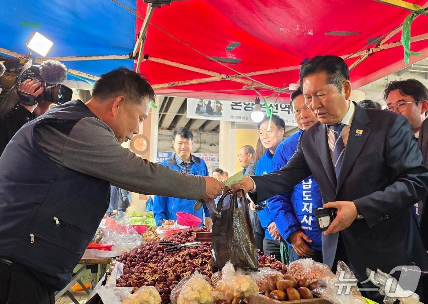 본문 이미지 - 4일 충남 아산 온양온천역을 방문한 정청래 더불어민주당 대표가 물건을 구입하고 있다. ⓒ 뉴스1 2026.4.4. 이시우 기자