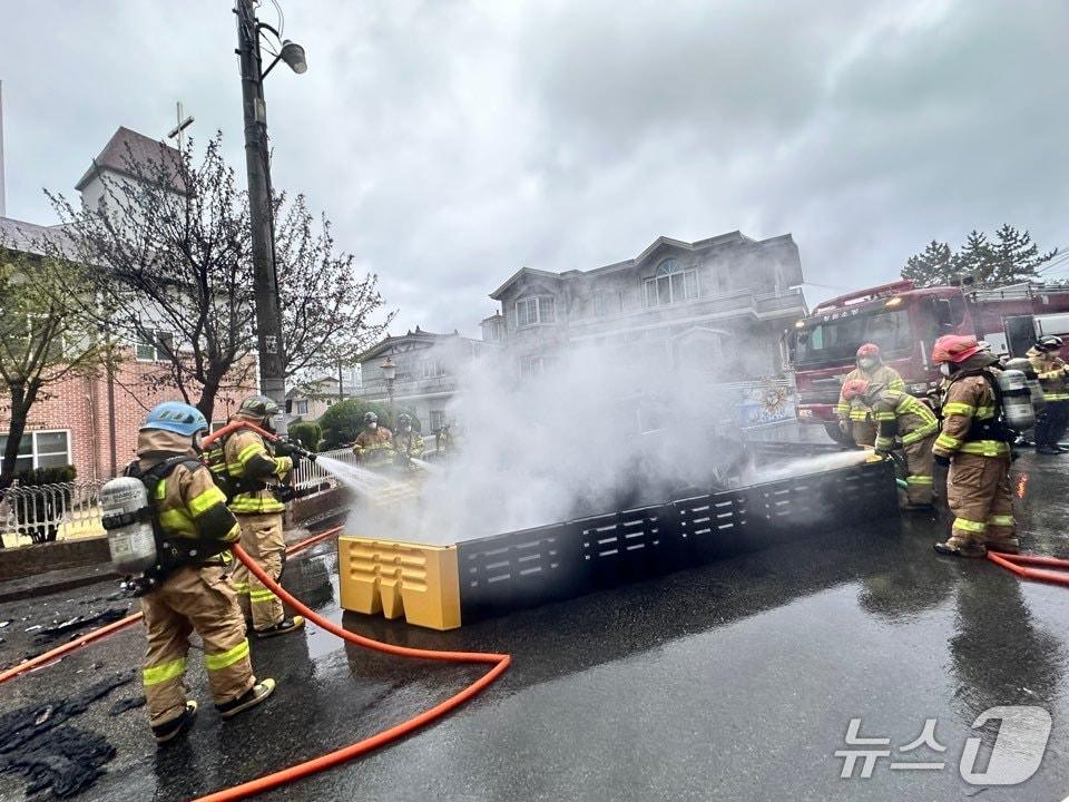 본문 이미지 - 4일 오전 6시 43분 쯤 전기택시가 도로 연석과 부딪히며 화재가 발생했다. 사진은 사고 현장에서 소방 당국이 화재 진압에 나서는 모습 (소방 제공. 재판매 및 DB금지)