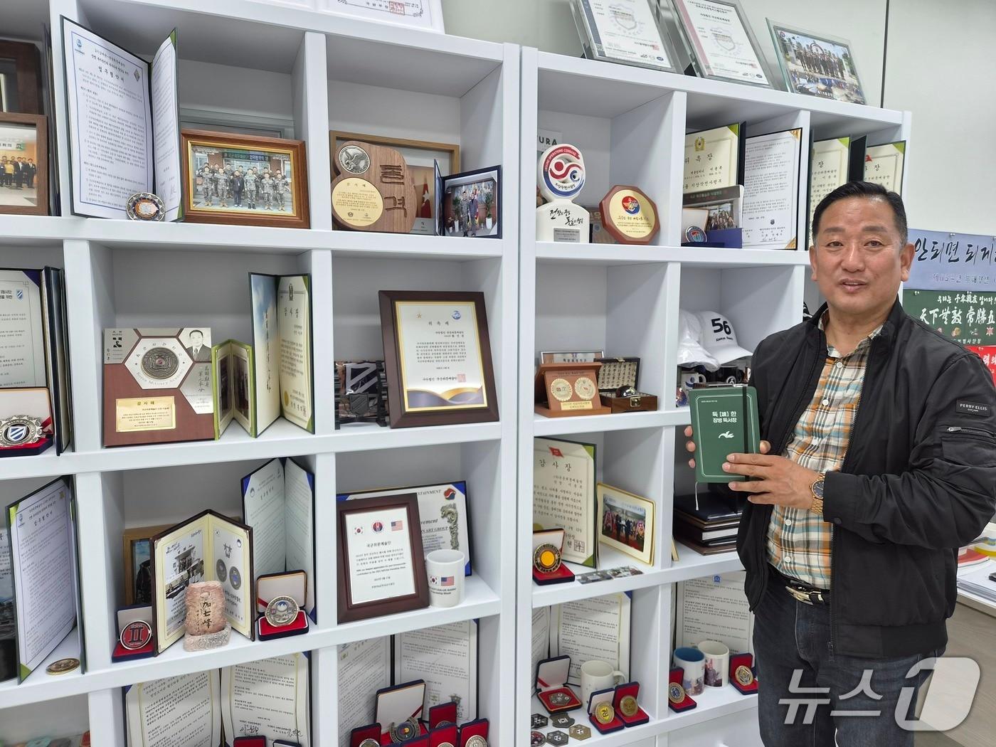 본문 이미지 - 이윤복 국군위문예술단 대표단장이 2일 서울 용산구 사무실에서 각종 위문 활동으로 받은 감사장, 위촉패 등을 소개하고 있다.