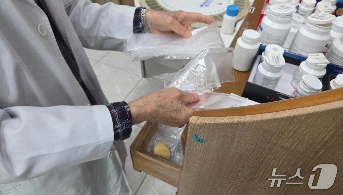 본문 이미지 - 5일 오후 1시 30분께 전북 전주시 완산구의 한 약국에서 근무하는 A 씨가 약국에서 사용하는 비닐 포장지를 꺼내고 있다.2026.4.5/뉴스1 문채연 기자