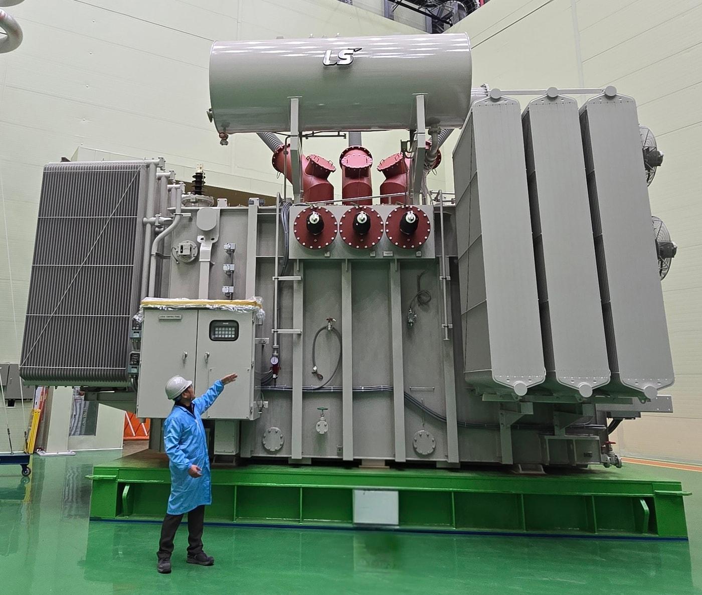 본문 이미지 - LS파워솔루션이 미국 에너지 인프라 기업과 약 7026만 달러(한화 약 1066억원) 규모의 초고압 변압기 공급 계약을 체결했다고 6일 밝혔다. 사진은 LS파워솔루션 울산 사업장에서 관계자가 초고압 변압기를 소개하는 모습