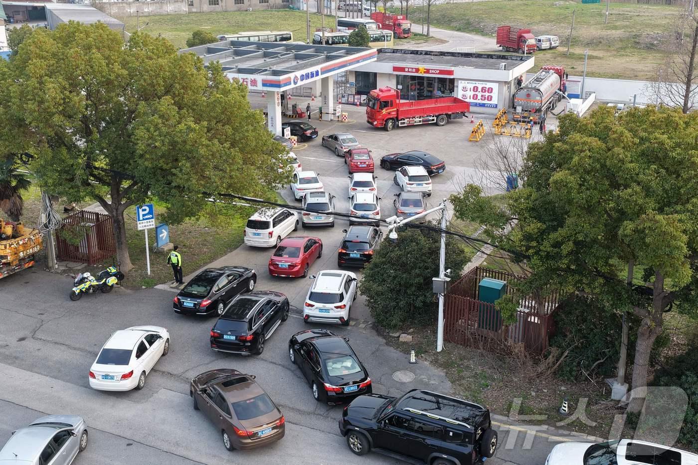 본문 이미지 - 중국 정제유 가격 인상을 앞둔 3월 22일 쑤저우의 한 주유소로 향하는 차량들이 길게 줄을 서 있다. 2026.3.22 ⓒ AFP=뉴스1