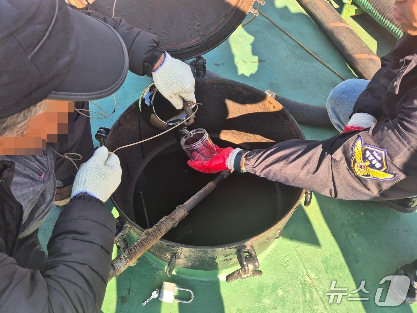 본문 이미지 - 유류 출처를 확인하기 위해 시료를 채취하는 모습 (해경 제공. 재판매 및 DB금지)