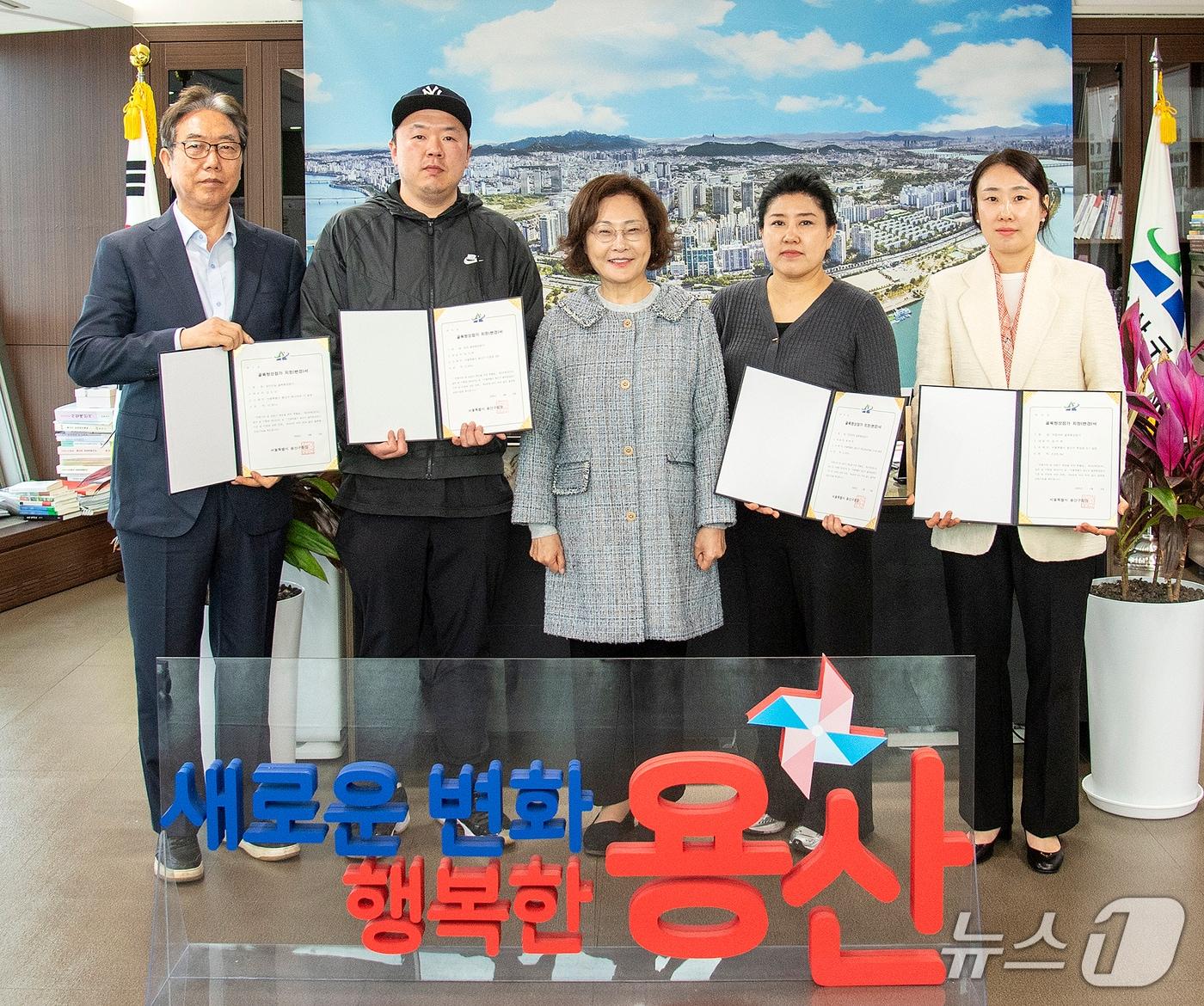 본문 이미지 - 박희영 용산구청장(왼쪽에서 세 번째)이 지난 6일 '골목형상점가'로 추가 지정된 상인들과 기념촬영을 하고 있다.(용산구 제공)