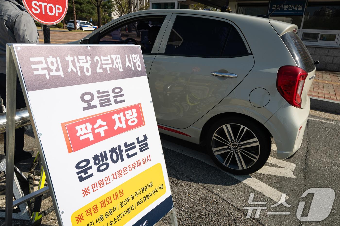 본문 이미지 - 공공기관 승용차 2부제가 시행된 8일 서울 여의도 국회에 차량 2부제 시행 안내문이 서 있다. 미국·이스라엘과 이란 간 전쟁으로 자원 안보 위기 경보가 3단계인 '경계' 단계로 격상됨에 따른 수요관리 강화 조치로 시행되는 2부제는 차량번호 끝자리를 기준으로 홀수일에는 홀수 차량, 짝수일에는 짝수 차량만 운행을 허용하는 방식이다. 2026.4.8 ⓒ 뉴스1 유승관 기자