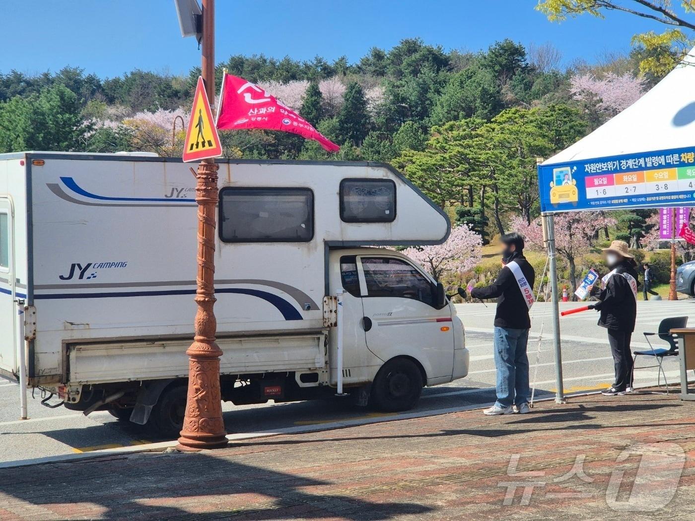 본문 이미지 - 자원 안보 위기경보 3단계 격상에 따라 공공기관 승용차 2부제, 공영주차장 승용차 5부제 시행 첫날인 8일 오전 강원 강릉시청 진입로에서 직원들이 출입차량 안내를 돕고 있다. 2026.4.8  ⓒ 뉴스1 윤왕근 기자