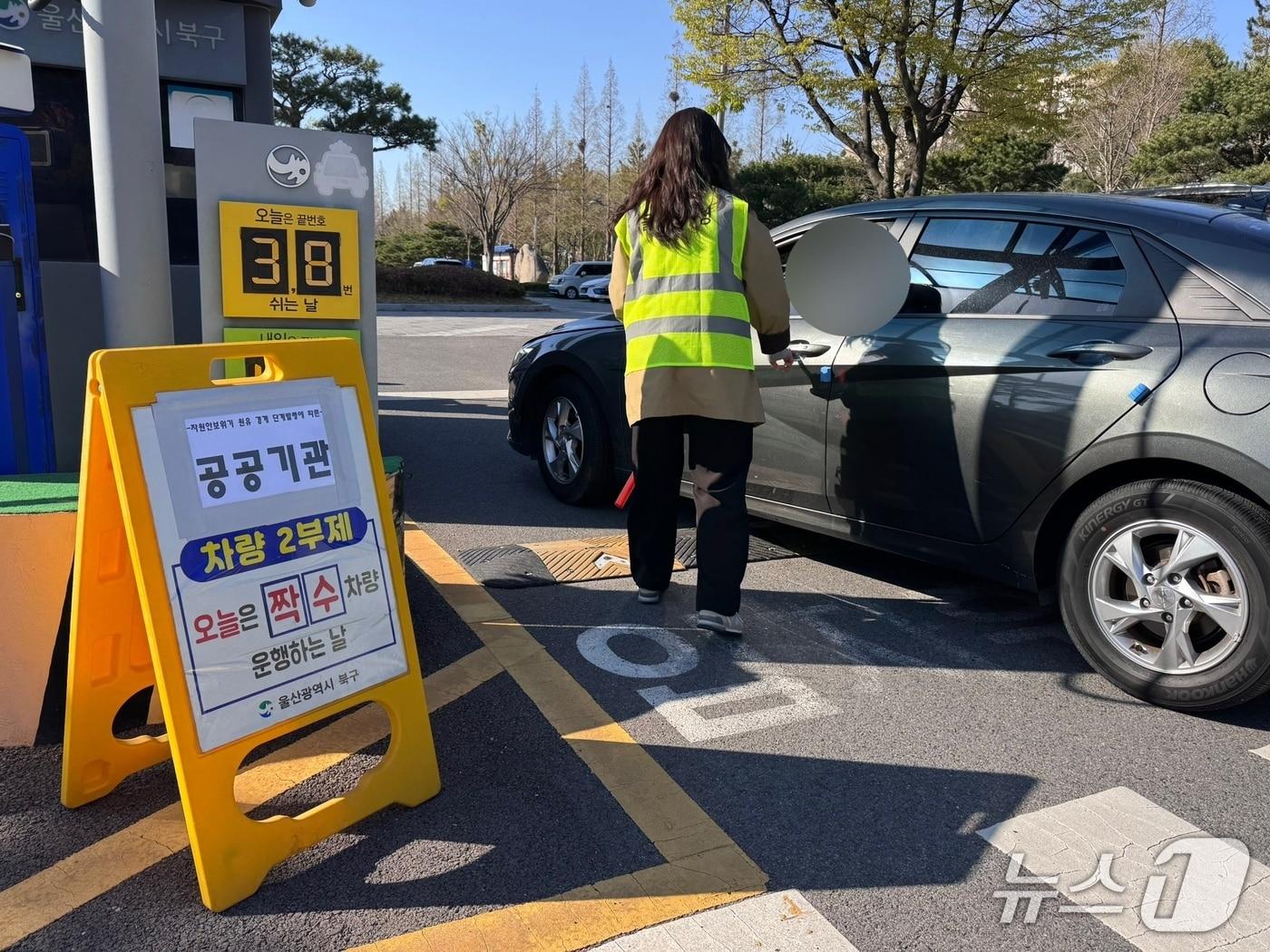 본문 이미지 - 공공기관 차량 2부제 시행 첫날인 8일 울산 북구청에서 직원이 주차장으로 들어오는 차량에 2부제 시행 사항을 알리고 있다.2026.4.8ⓒ 뉴스1 김세은 기자
