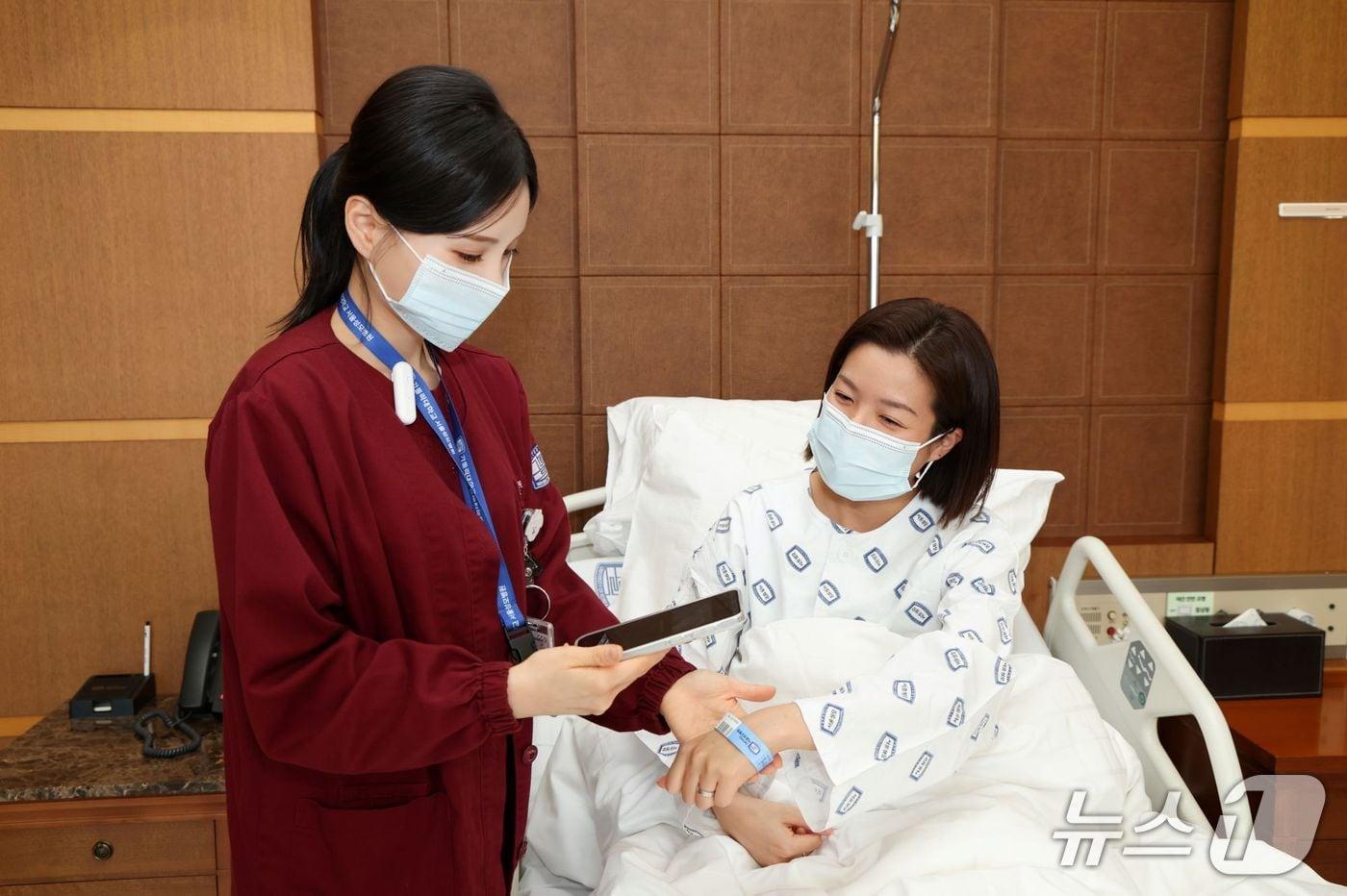 본문 이미지 - 서울성모병원 간호사가 Voice ENR(모바일 기기)을 통해 환자의 손목 밴드를 스캔하며 환자 및 투약 이중 확인을 진행하고 있다.(서울성모병원 제공)