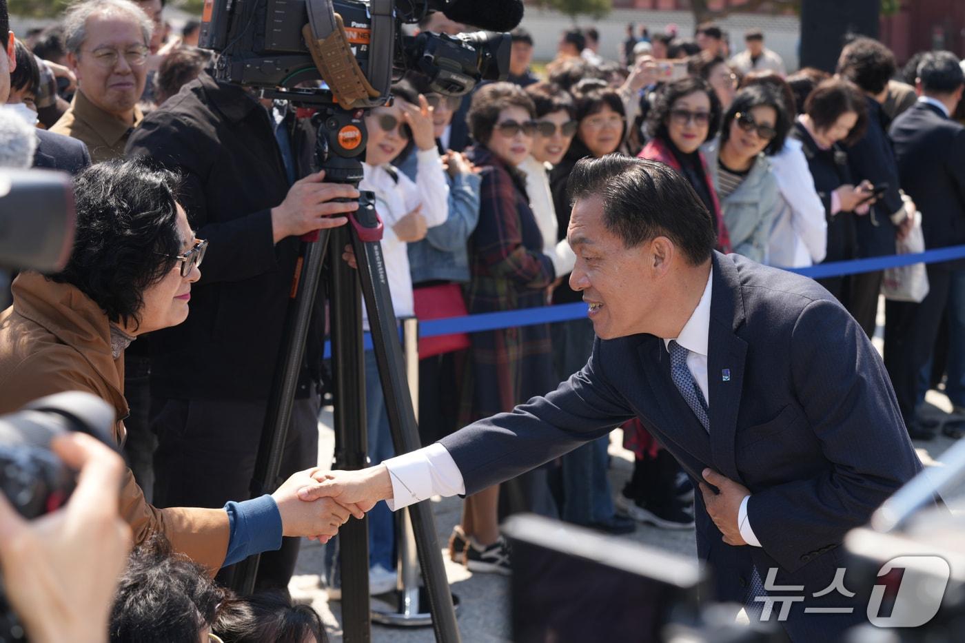 본문 이미지 -  이재준 경기 수원시장이 8일 오후 화성행궁 광장에서 기자회견을 열고 재선 도전을 공식 선언했다. 사진은 이 시장이 시민들과 악수를 나누는 모습. 2026.4.8/뉴스1
