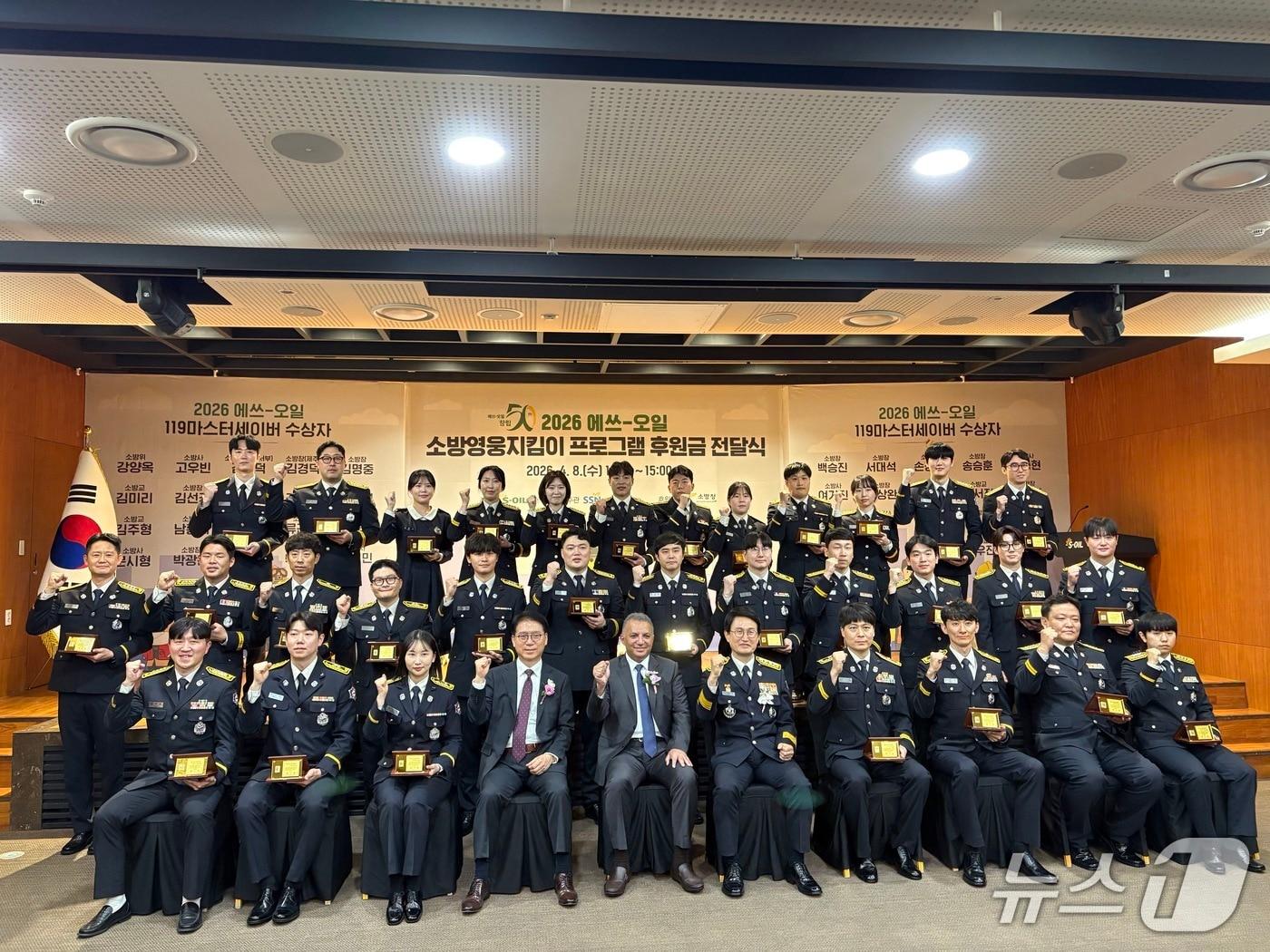 본문 이미지 - 8일 열린 '2026년 119마스터세이버 시상식'에서 김승룡 소방청장 등 주요 내빈들과 영예로운 119마스터세이버로 선정된 구급대원 수상자들이 국민의 생명을 지키기 위한 헌신을 다짐하며 단체 기념사진을 촬영하고 있다.(소방청 제공)