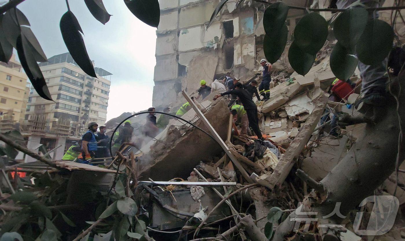 본문 이미지 - 8일(현지시간) 레바논 베이루트 탈레트 알-카이야트 지구의 이스라엘의 공습 현장에 구조대원과 주민들이 모여 있다. 레바논 보건부에 따르면 이날 하루 동안 레바논에서 최소 112명이 숨지고 837명이 다쳤다. 2026.04.08. ⓒ AFP=뉴스1