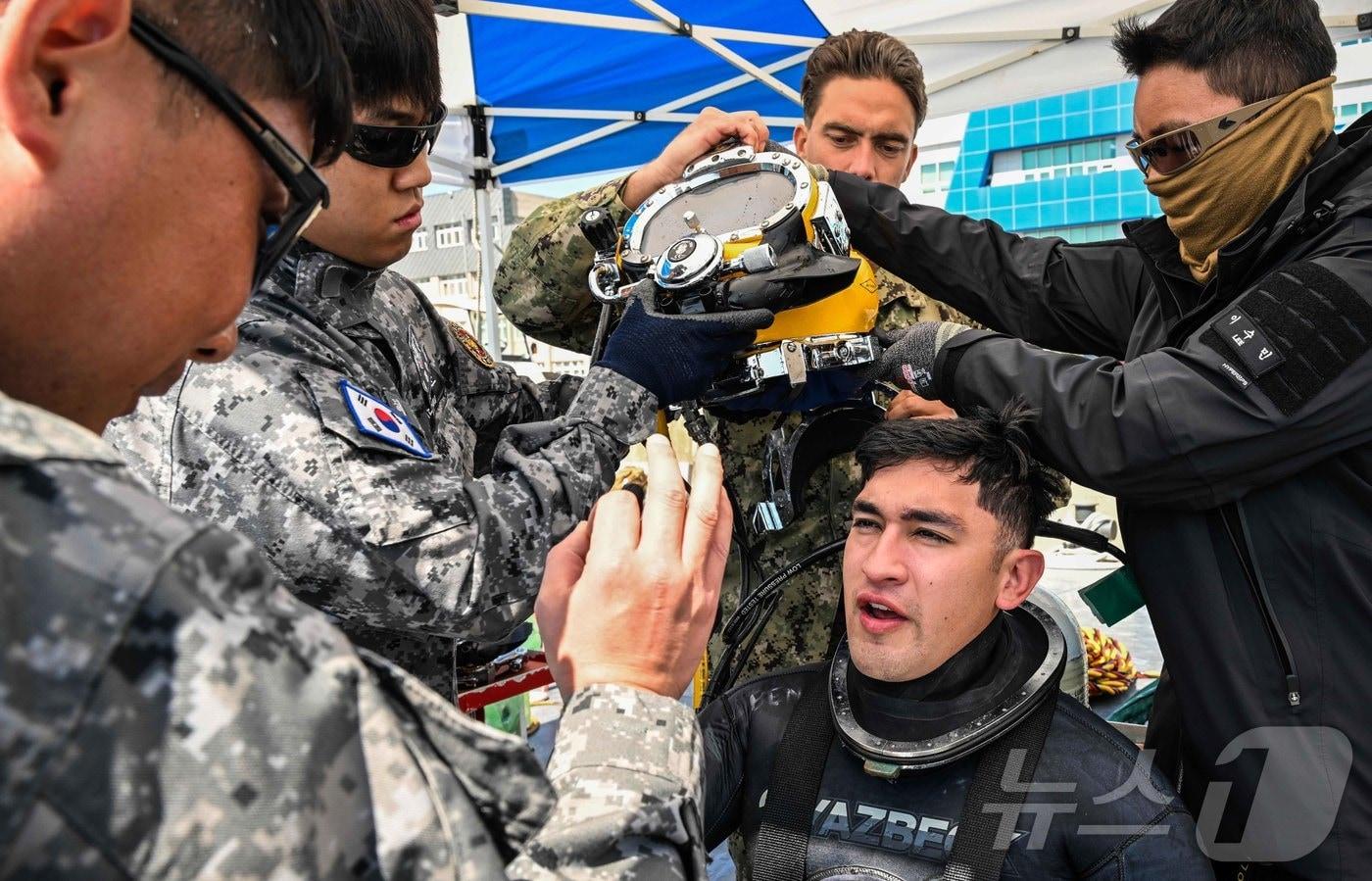 본문 이미지 - 8일 경남 진해만 일대에서 진행된 연합 구조전 훈련에서 해군 해난구조전대(SSU) 심해잠수사들이 표면공급잠수체계 운용 훈련을 마친 미 해군 기동잠수구조부대(MDSU) 잠수사의 건강 상태를 확인하고 있다. (해군 제공. 재판매 및 DB 금지) 2026.4.9 ⓒ 뉴스1