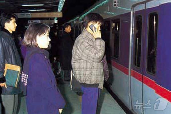 본문 이미지 -  고객이 지하철을 기다리며 이동전화 서비스를 이용하는 모습 (SK텔레콤 제공)