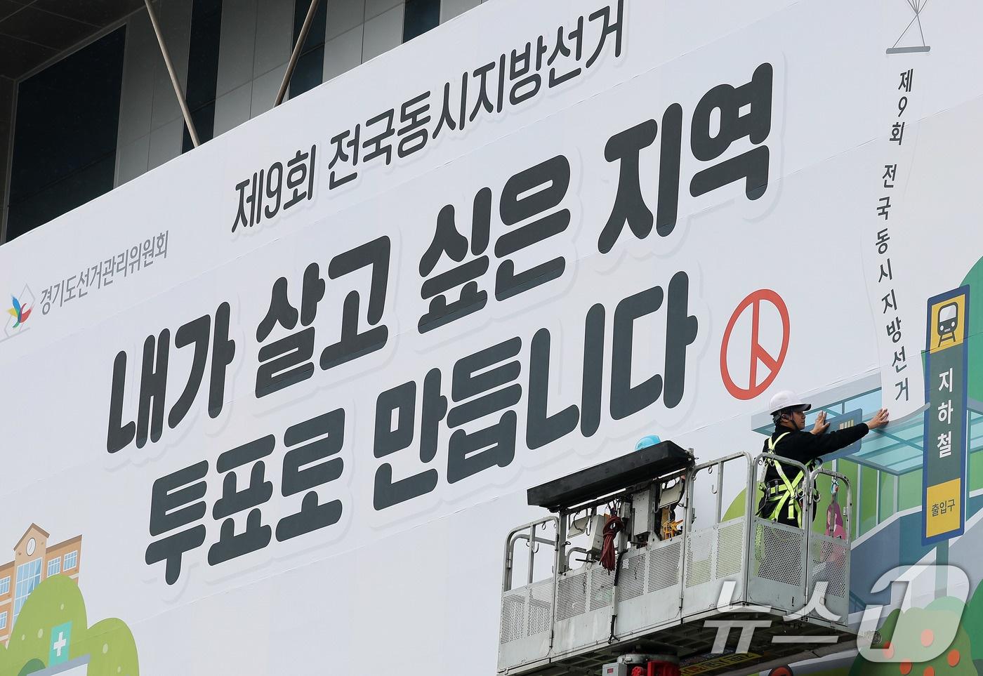 본문 이미지 - 제9회 전국동시지방선거를 앞둔 9일 경기도 수원시 영통구 경기도선거관리위원회 청사 외벽에 관계자들이 투표참여를 독려하는 대형 현수막을 설치하고 있다. 2026.4.9 ⓒ 뉴스1 박지혜 기자