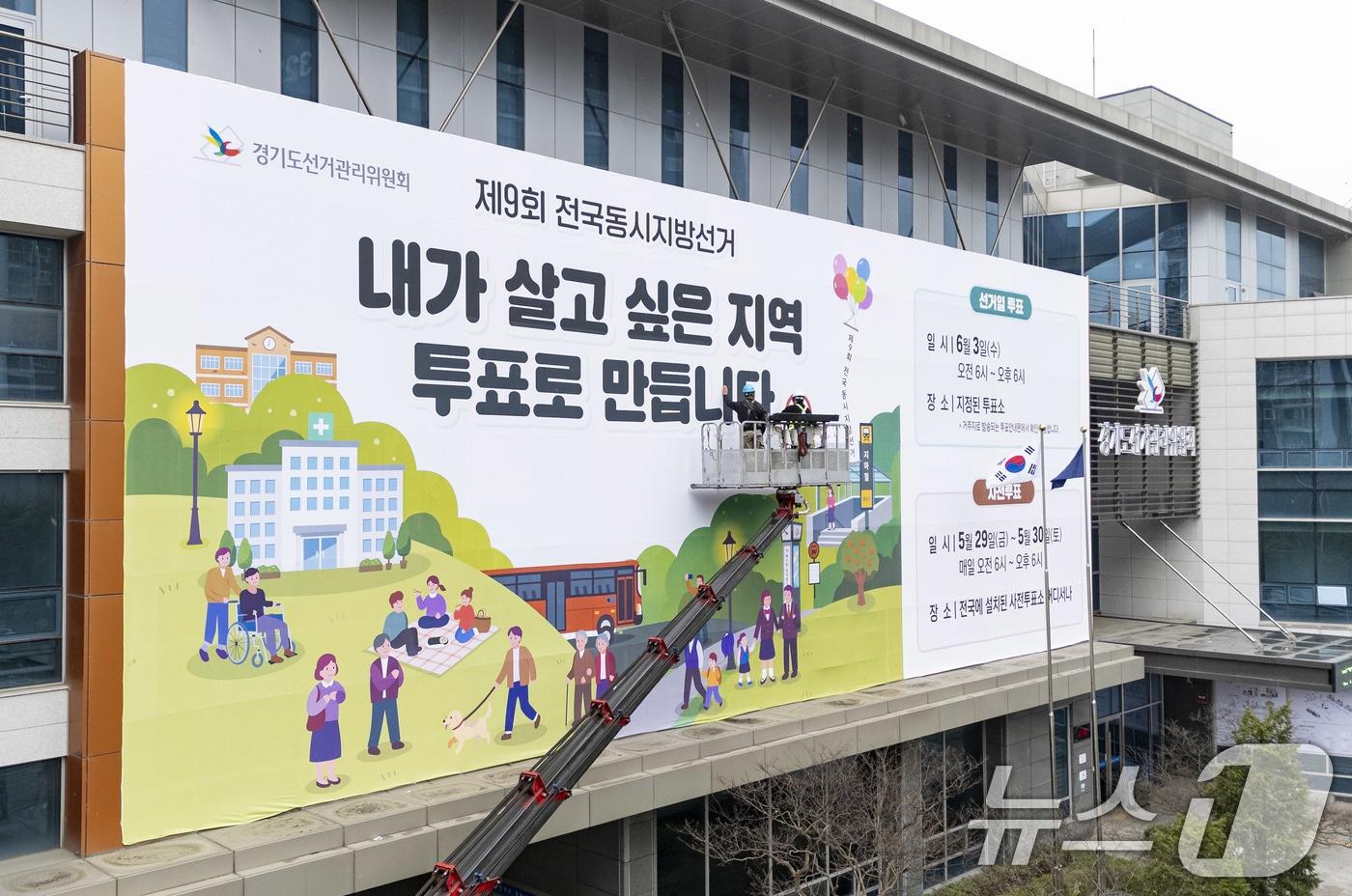 본문 이미지 - 제9회 전국동시지방선거를 앞둔 9일 경기도 수원시 영통구 경기도선거관리위원회 청사 외벽에 관계자들이 투표참여를 독려하는 대형 현수막을 설치하고 있다.(공동취재) 2026.4.9 ⓒ 뉴스1 박지혜 기자