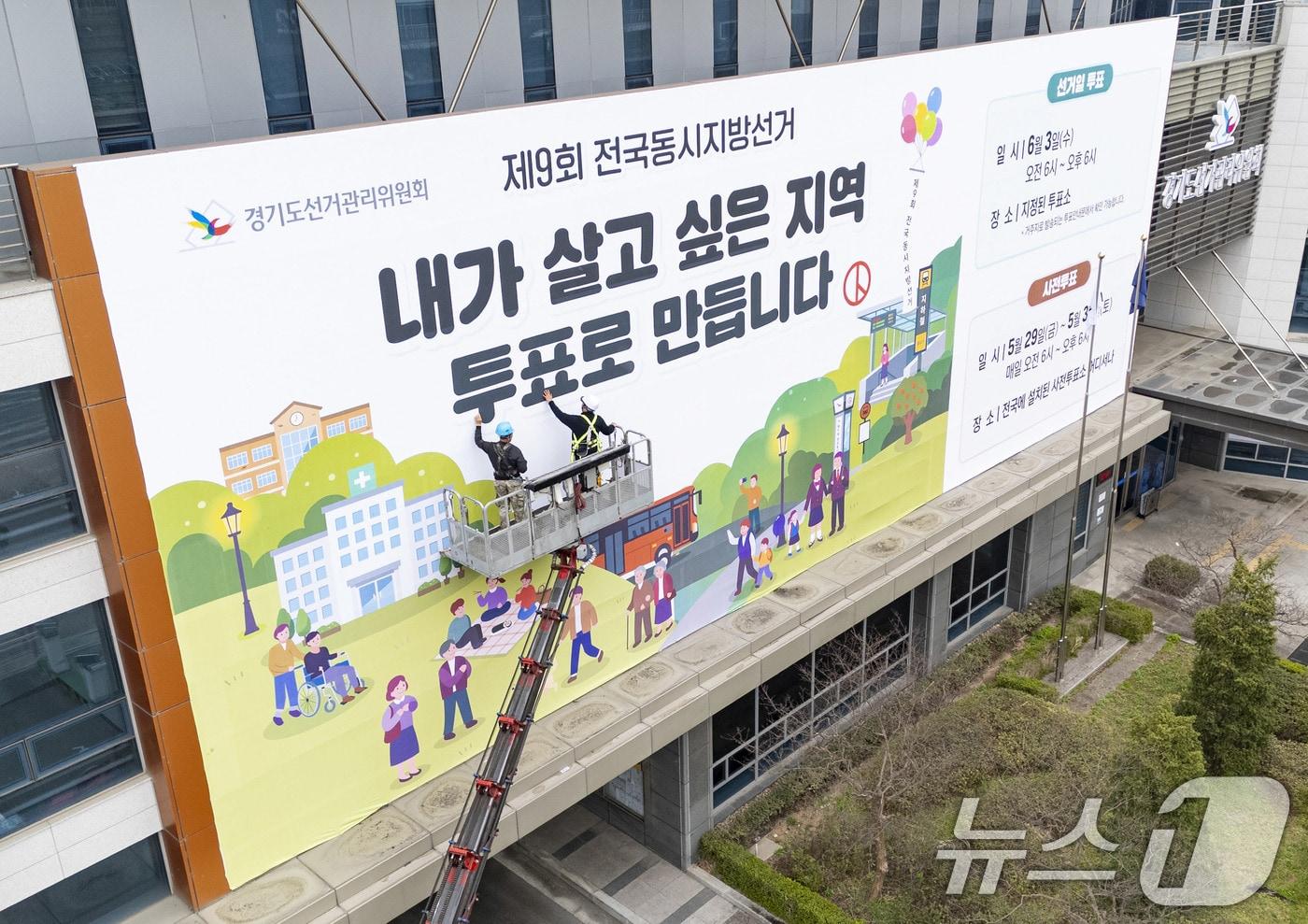 본문 이미지 - 제9회 전국동시지방선거를 앞둔 지난 9일 경기도 수원시 영통구 경기도선거관리위원회 청사 외벽에 관계자들이 투표참여를 독려하는 대형 현수막을 설치하고 있다.(공동취재) 2026.4.9 ⓒ 뉴스1 박지혜 기자
