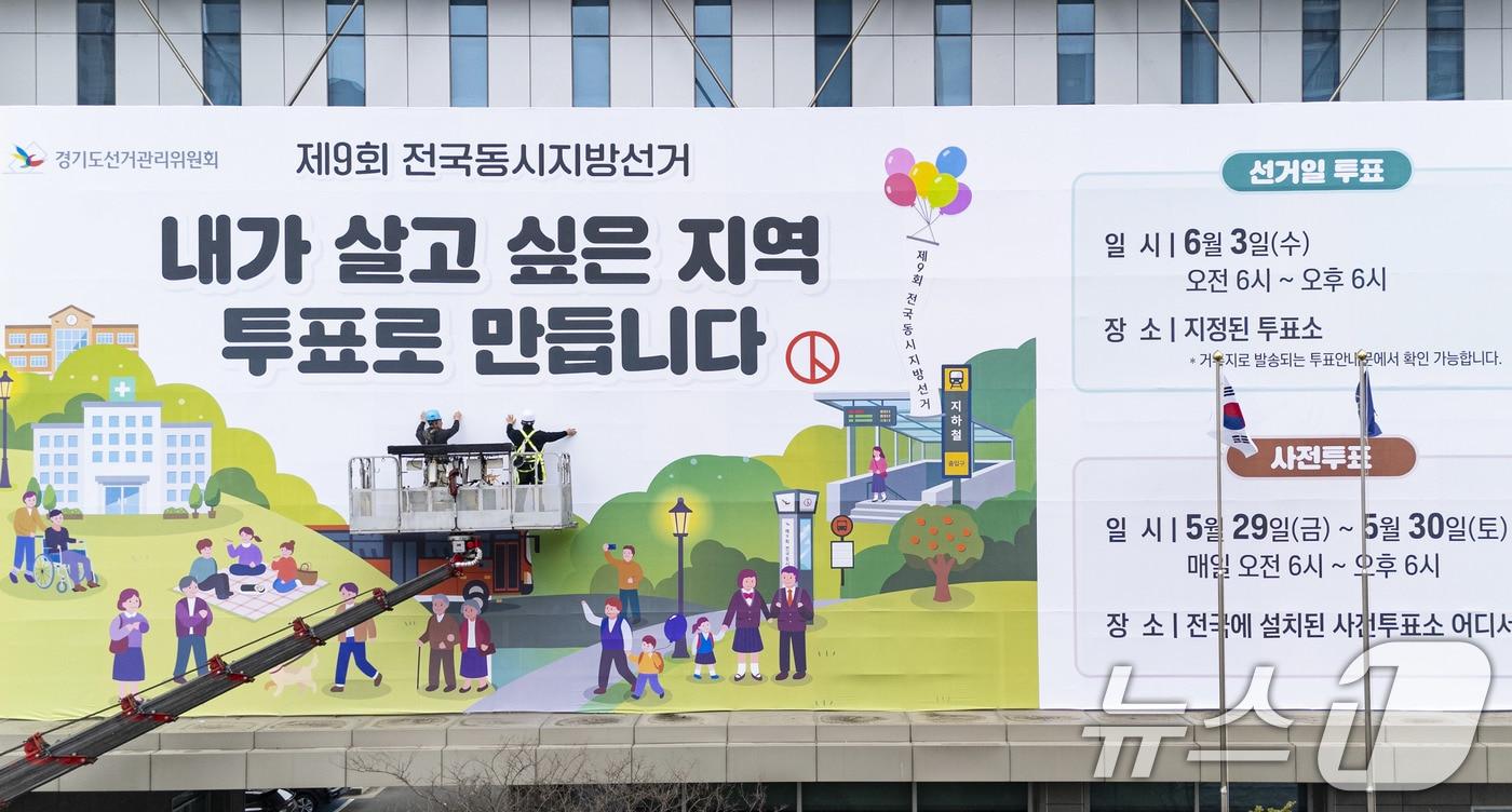 본문 이미지 - 제9회 전국동시지방선거를 앞둔 9일 경기도 수원시 영통구 경기도선거관리위원회 청사 외벽에 관계자들이 투표참여를 독려하는 대형 현수막을 설치하고 있다.(공동취재) 2026.4.9 ⓒ 뉴스1 박지혜 기자