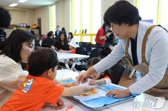 본문 이미지 - 송미령 농림축산식품부 장관이 충북 충주 신니면 내포긴들체험마을에서 아이들과 사과 피자를 만들고 있다.(충주시 제공. 재판매 및 DB금지)