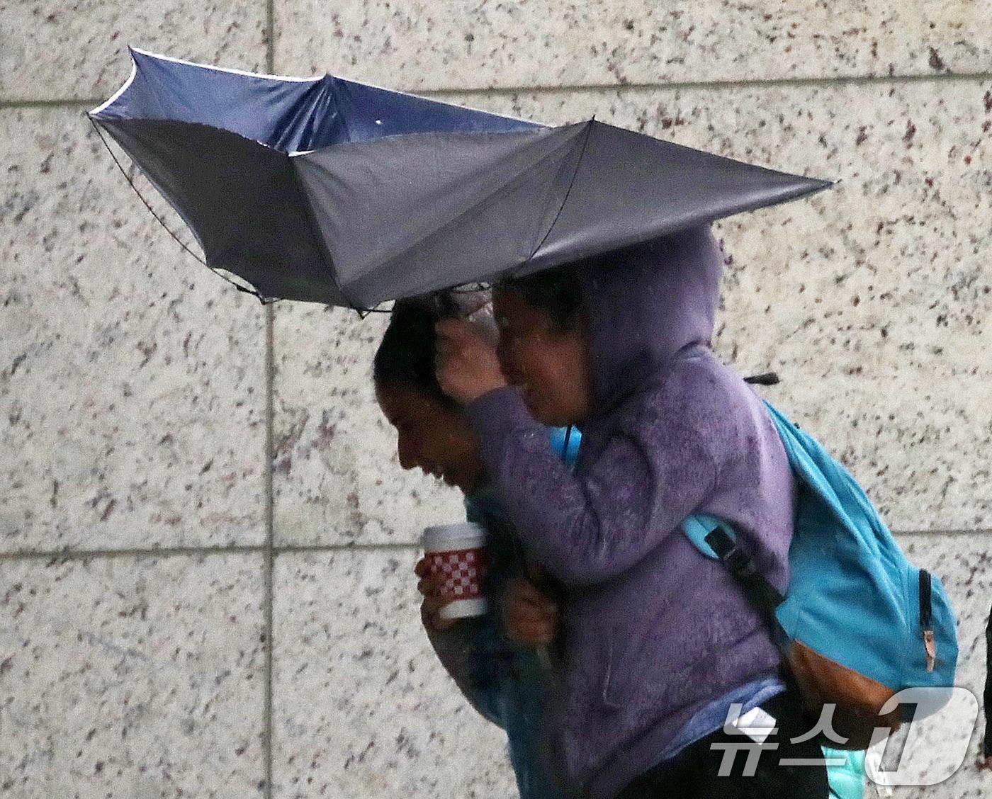 본문 이미지 - 전국적으로 비가 내리는 9일 오후 부산 해운대해수욕장 인근에서 외국인 관광객들이 강풍에 우산을 부여잡고 힘겹게 발걸음을 옮기고 있다. 2026.4.9 ⓒ 뉴스1 윤일지 기자