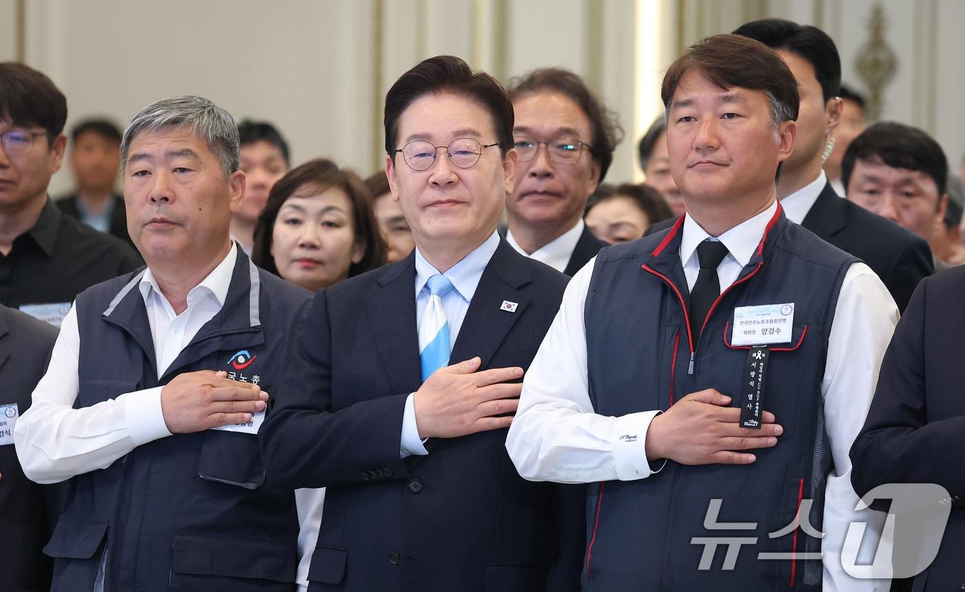 본문 이미지 - 이재명 대통령이 1일 청와대 영빈관에서 열린 2026 노동절 기념식에서 국민의례를 하고 있다. 왼쪽부터 김동명 한국노총 위원장, 이재명 대통령, 양경수 민주노총 위원장. 2026.5.1 ⓒ 뉴스1 허경 기자