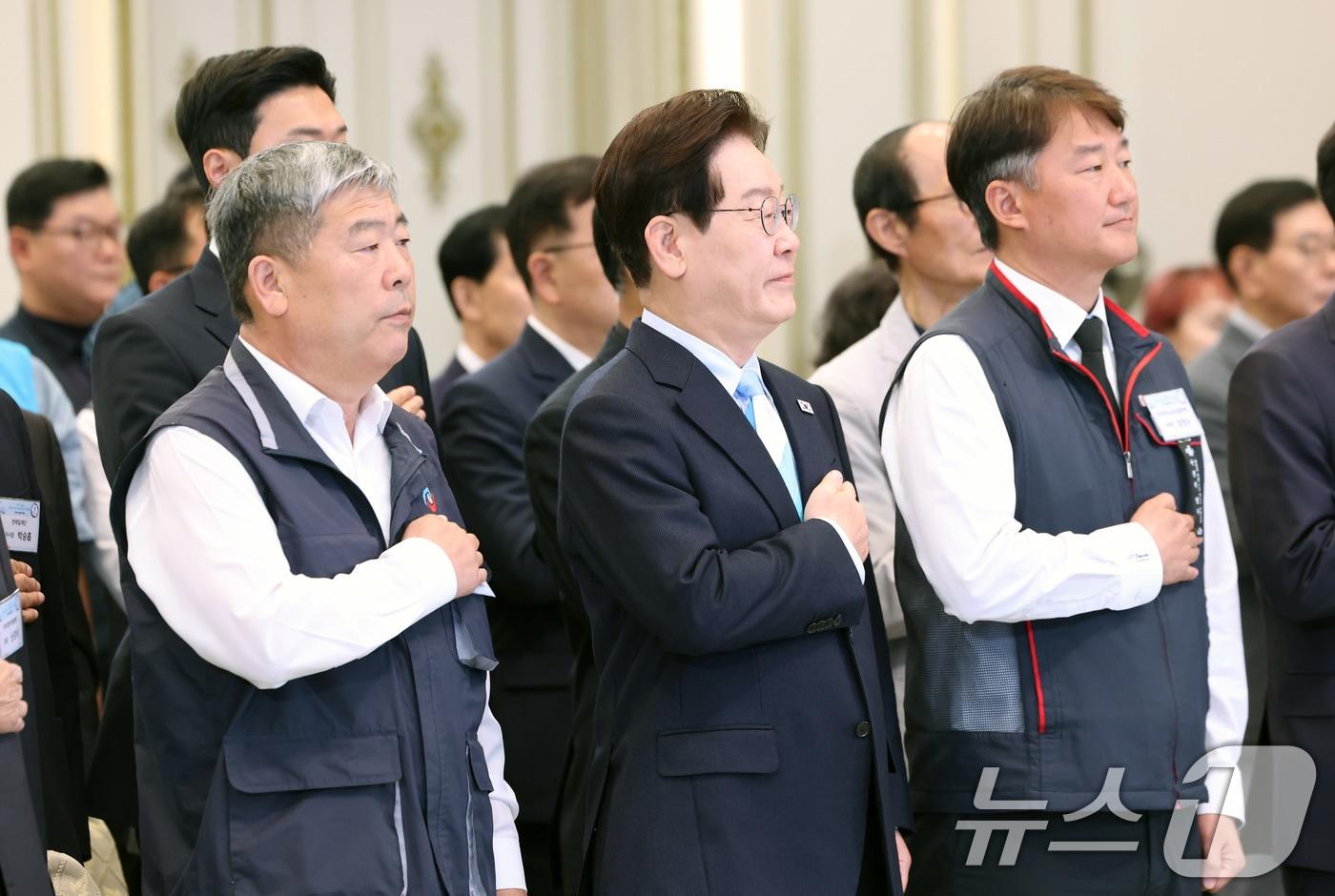 본문 이미지 - 이재명 대통령이 지난 5월 1일 청와대 영빈관에서 열린 2026 노동절 기념식에서 국민의례를 하고 있다. 왼쪽부터 김동명 한국노총 위원장, 이재명 대통령, 양경수 민주노총 위원장. 2026.5.1 ⓒ 뉴스1 허경 기자
