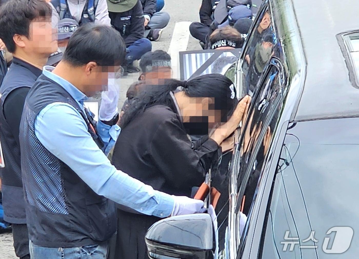 본문 이미지 - 민주노총 화물연대 집회 현장에서 사망한 A 씨의 추모제가 열린 1일 A 씨 유족이 운구차 안을 들여다보며 오열하고 있다. 2026.5.1/뉴스1 한송학기자