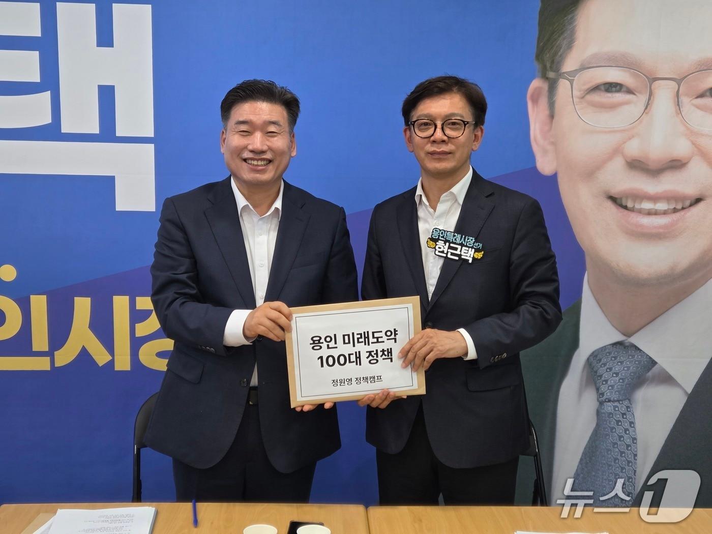 본문 이미지 - 현근택 용인시장 후보(오른쪽)가 지난달 30일 정원영 전 예비후보로부터 ‘용인 미래도약 100대 정책’을 전달받고 있는 모습.(후보측 제공)