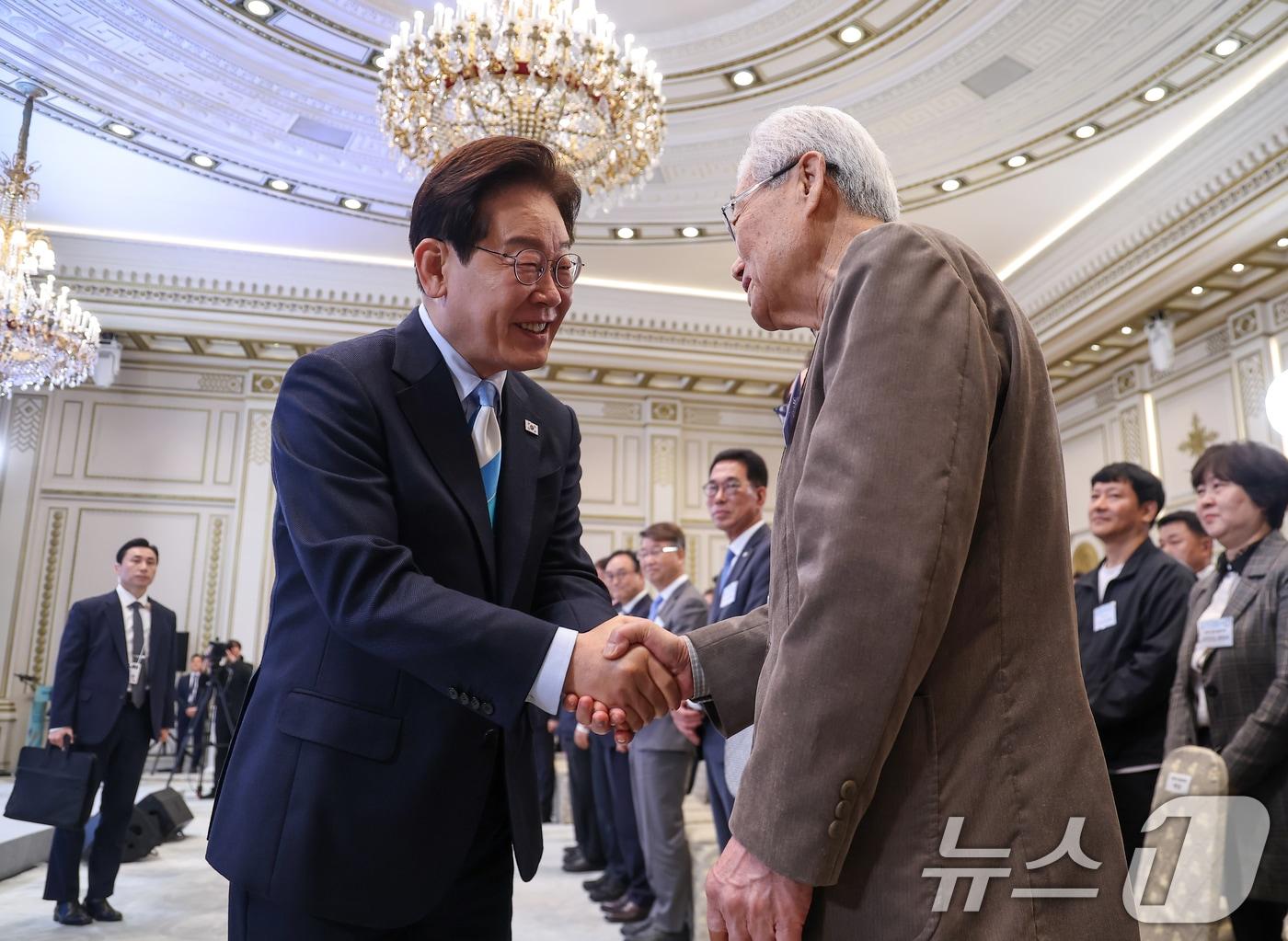본문 이미지 - 이재명 대통령이 1일 청와대 영빈관에서 열린 2026 노동절 기념식에서 천영세 민주노총 지도위원과 악수하고 있다. 2026.5.1 ⓒ 뉴스1 허경 기자