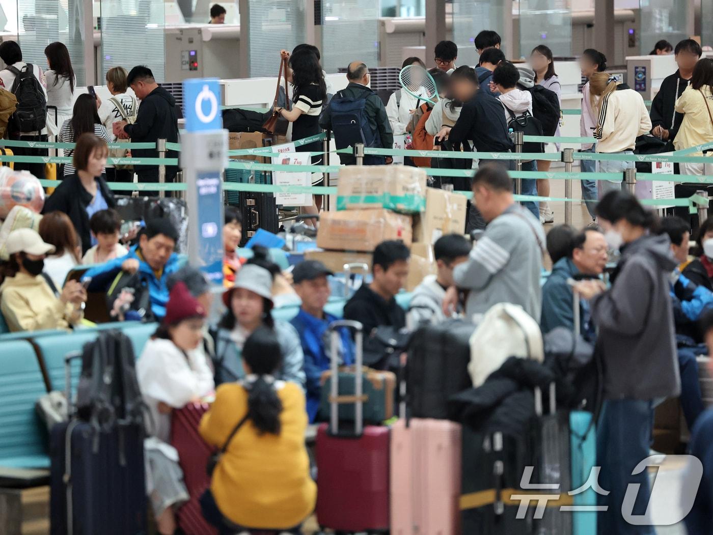 본문 이미지 - 올해 법정공휴일로 지정된 노동절과 어린이날을 낀 징검다리 연휴 기간인 1일 인천국제공항 입국장에서 승객들이 출국수속을 하고 있다.  2026.5.1 ⓒ 뉴스1 황기선 기자